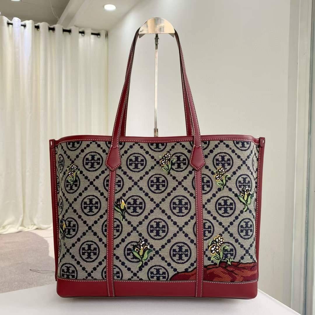 Tory Perry Embroidered T Monogram Triple Compartment Tote Bag เป็นแพทเทิร์นที่ได้รับแรงบันดาลใจจากการควิลท์สไตล์เพนซิลเวเนียดัตซ์ดั้งเดิมและเฉลิมฉลองโลโก้อันเป็นสัญลักษณ์ของแบรนด์ วัสดุผ้าแจ็คการ์ดแบบทอหนัง อะไหล่ทอง โดดเด่นด้วยลายเสือชีร์ต้าร์ งานเย็บปัก