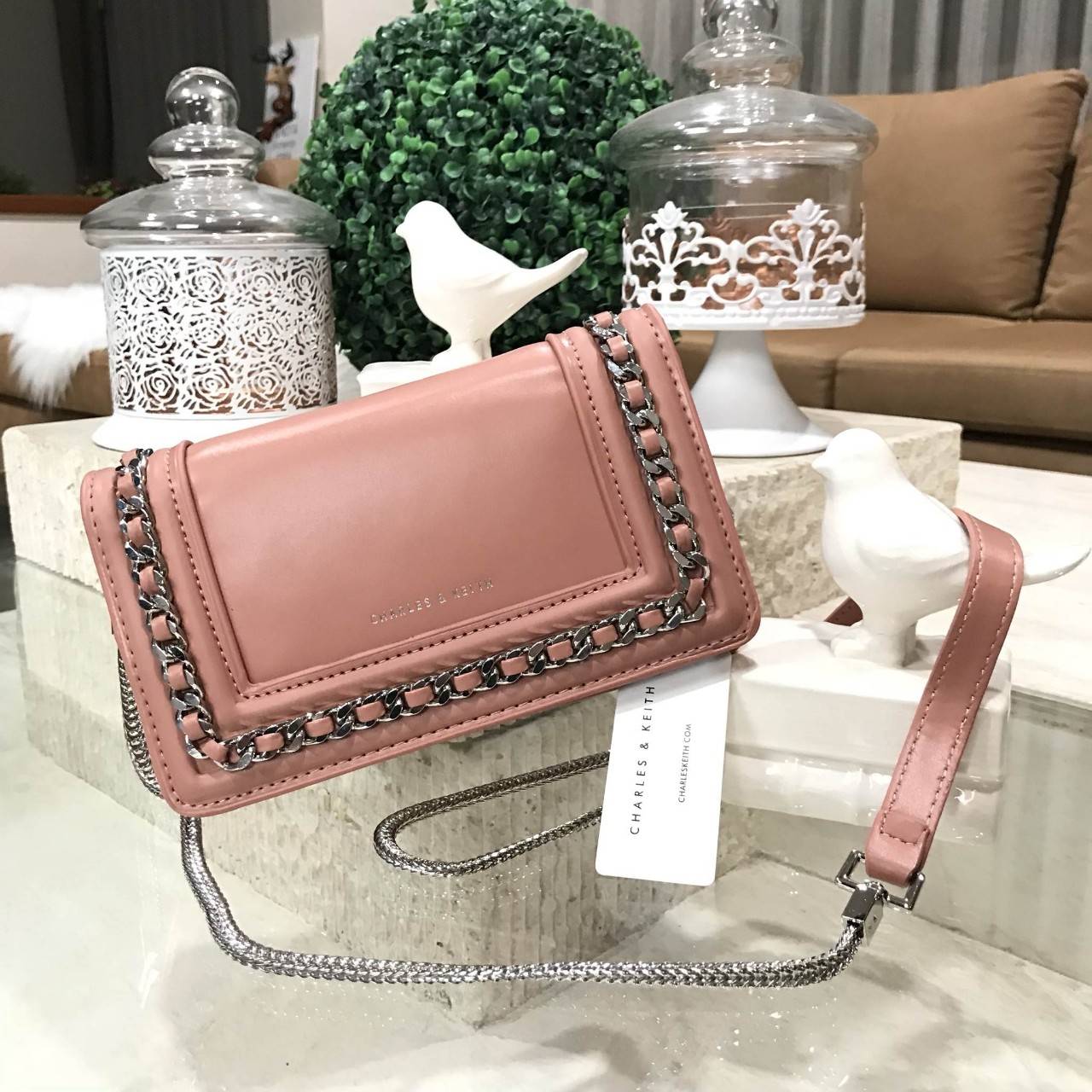 NEW ARRIVAL! CHARLES & KEITH CHAIN DETAIL CROSSBODY BAG กระเป๋าสะพายทรงสี่เหลี่ยมรุ่นชนช็อปขนาดกำลังดีวัสดุหนังนิ่มเรียบประดับด้วยโซ่ด้านหน้าดูมีดีเทล เปิดปิดด้วยกระดุมแม่เหล็ก ภายในมีช่องใส่บัตรและช่องซิป มาพร้อมสายโซ่ต่อหนังถอดถือเป็นคลัชได้ ภาพถ่ายสินค