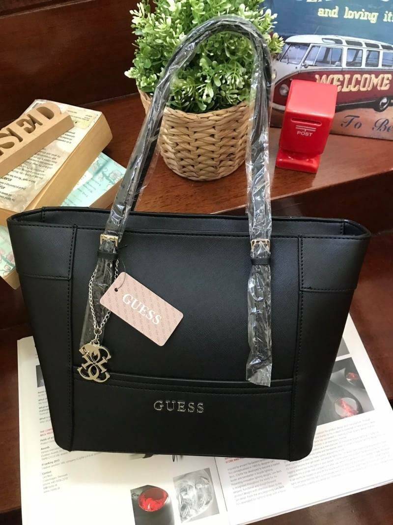 GUESS SHOPPER BAG กระเป๋าถือทรง Tote วัสดุหนังลาย Saffiano สวยอยู่ทรงสไตล์ PRADA ขนาดใหญ่ น้ำหนักเบา ด้านหน้าปั้มโลโก้แบรนด์ ประดับโลหะTAG โลโก้ตัว G อะไหล่เงินที่หูกระเป๋าถอดเเยกใช้ได้ เปิดปิดด้วยซิปเดียวใช้งานง่ายภายในมีsignature ยังมีช่องซิปและช่องเล็ก