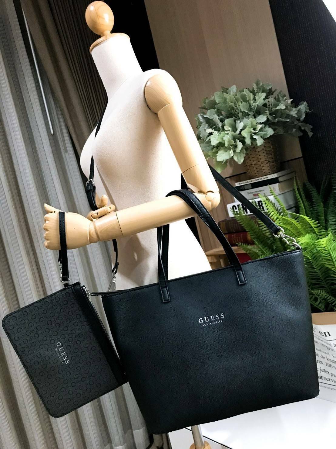 GUESS LARGE SHOPPER BAG WITH POUCH กระเป๋าสะพายรุ่นใหม่ล่าสุดจาก GUESS FACTORY หนัง Saffiano สวยหรูอยู่ทรง ด้านหน้ามีโลโก้แบรนด์ ด้านหลังมีช่องใส่ของ หูหิ้วสะพายไหล่ได้มาพร้อมสายสะพายยาวถอดได้ปรับได้ มีกระเป๋าใบเล็กเข้าชุดกันห้อยที่หูหิ้ว ใบเล็กถอดเเยกใช้