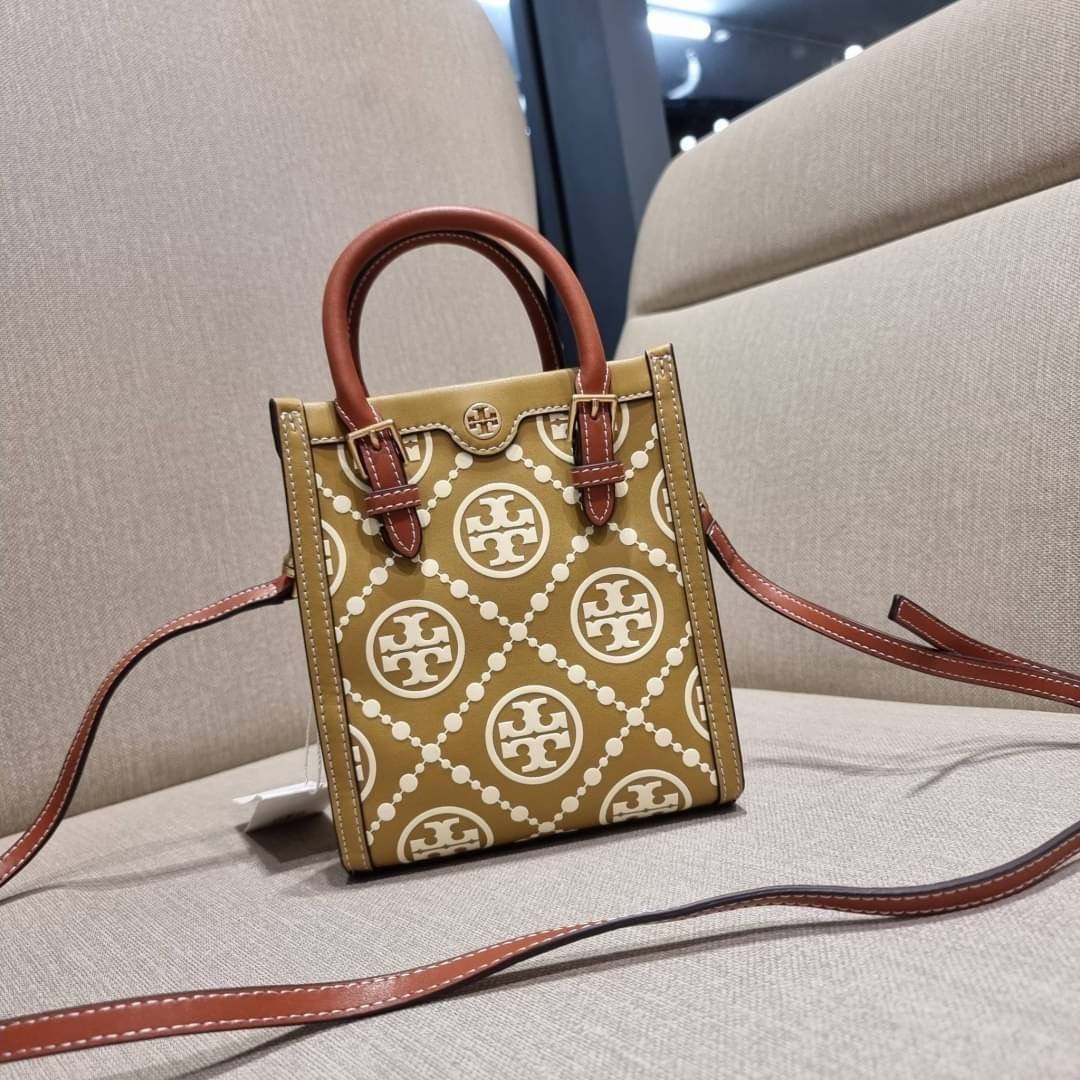 TORY BURCH T MONOGRAM EMBOSSED MINI TOTE สุดหรูกับกระเป๋าสะพายทรงโท้ท ไซส์มินิ ที่สร้างความหรูหราให้ตัวกระเป๋าด้วยดีเทลลายนูน แต่งแต้มลวดลายเอกลักษณ์ สีลูกคุณมากๆ!! วัสดุหนังแท้ ผิวสัมผัสดี ปากกระเป๋ามีแถบแม่เหล็กกันของหล่นได้ ภายในโล่ง ใส่ของจำเป็นได้ โท
