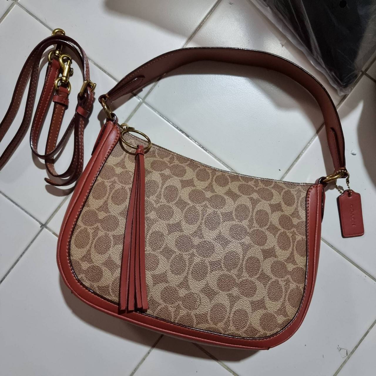 COACH 52577 SUTTON CROSSBODY IN SIGNATURE CANVAS กระเป๋าสะพายไหล่ สวยคลาสสิค สไตล์วินเทจ ใบใหญ่จุใจ วัสดุหนังแคนวาสเคลือบลาย สายคล้องไหล่ในตัว ภายในโล่งกว้าง จุของได้เยอะแน่นๆ มาพร้อมสายสะพาย crossbody ที่จะถอดออก หรือจะสะพายก็เก๋ สวยโดดเด่นแน่นอน พร้อมเส