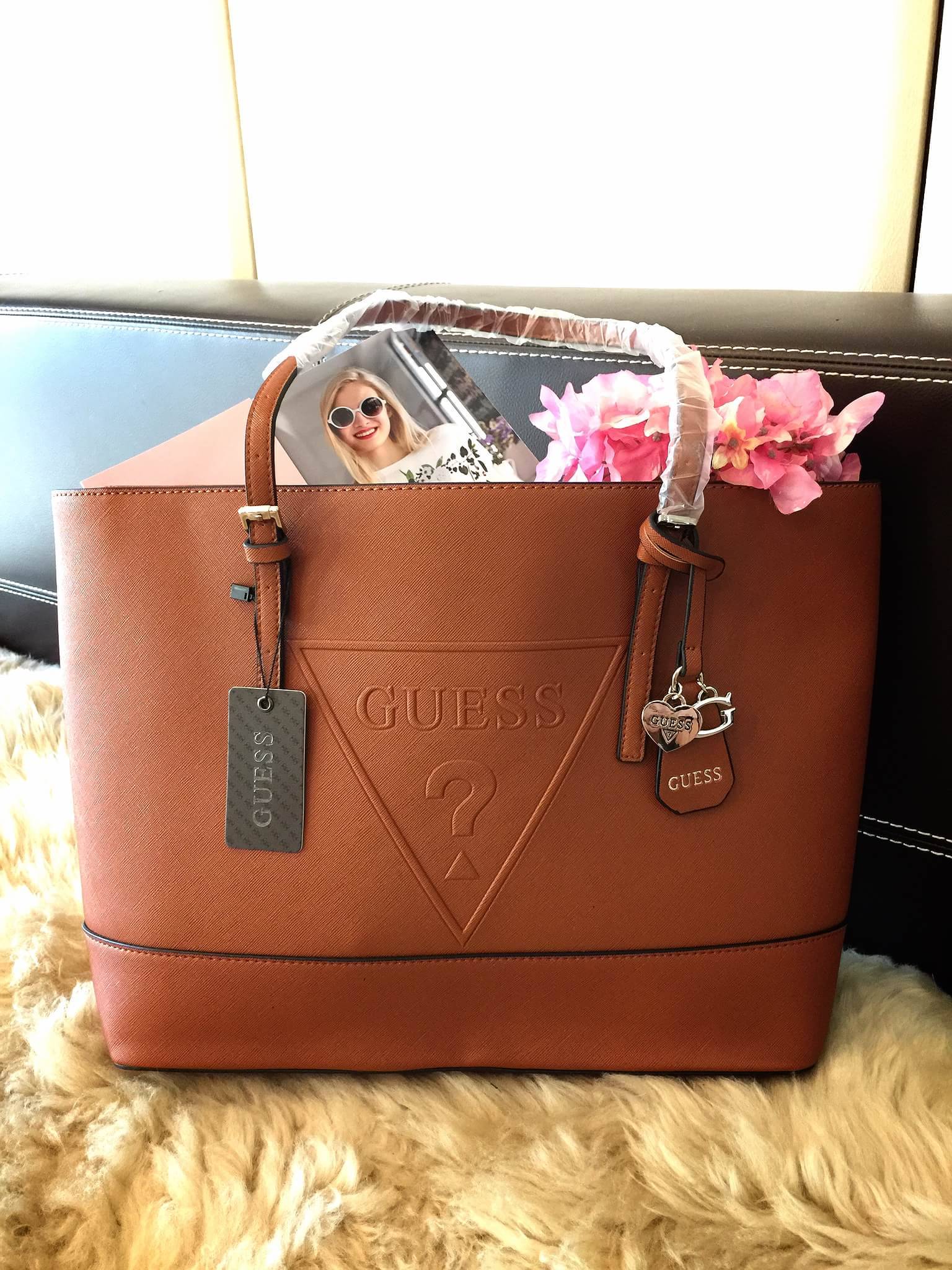 Guess Saffiano Shopping Bag กระเป๋าถือและคล้องบ่าทรงช้อปปิ้งใบใหญ่ หนังSaffiano ใส่เอกสารขนาด A4 ได้ จุของได้เยอะ ด้านหน้าสลักแบรนด์หนังลายนูนพร้อมประดับtagสายหนังถอดออกได้ เปิดปิดด้วยซิปเดียวด้านบน ภายในบุผ้าติดโลโก้ มีช่องเล็กและข่องใส่โทรศัพท์ เรียบง่า