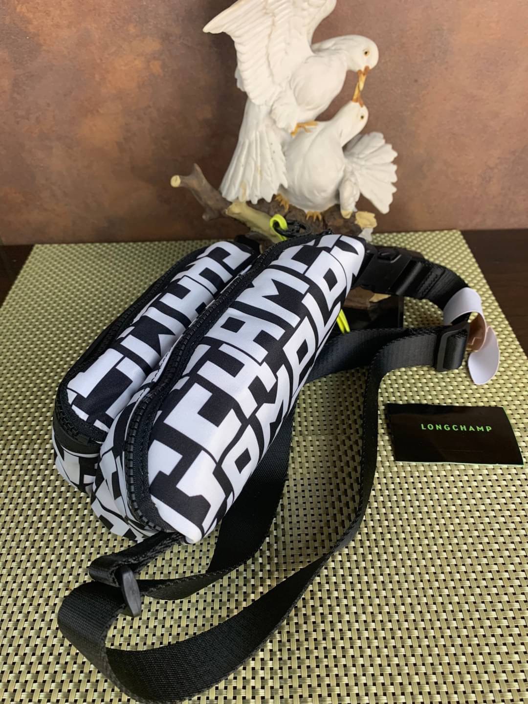 LONGCHAMP LE PLIAGE LGP BELT BAG M เท่ห์อย่างมีสไตล์กระเป๋าทรงคาดอกและคาดเอวดีไซน์แนวสปอร์ต เพิ่มความโดดเด่นทันสมัยด้วยลายซิกเนเจอร์ มีช่องซิปที่ใช้งานง่ายช่วยให้คุณหยิบใช้สิ่งของจำเป็นได้อย่างสะดวกและง่ายดาย และผสานสายรัดแบบปรับได้เข้ากับหัวเข็มขัดตัวล็อ