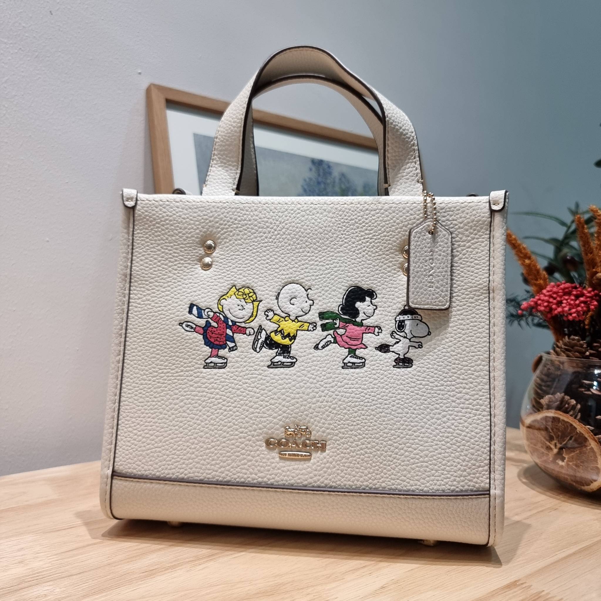 Coach X Peanuts Dempsey Tote 22 With Snoopy And Friends Motif CE850 คอลเลคชั่นใหม่ น้องน่ารักเกินต้านไปมาก!! กับกระเป๋าทรงโท้ท ไซส์กำลังสวย ดีไซน์ ลายการ์ตูนยอดฮิต ที่ใครๆก็ต้องรู้จัก พิมพ์คมชัดลงบนหนัง pepble ผิวสัมน่าใช้ ปากกระเป๋ามีกระดุมแม่เหล็กปิดกัน