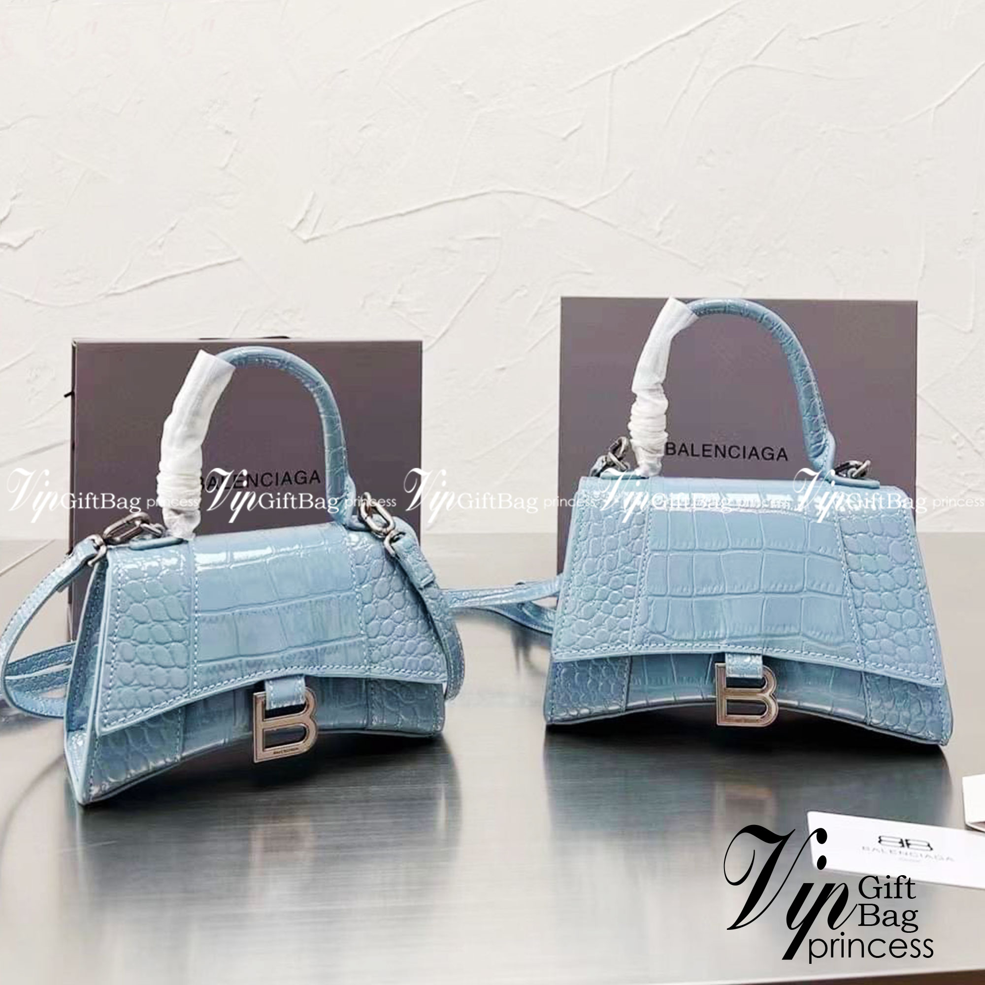 BALENCIAGA Hourglass BAG XS S / BALENCIAGA Hourglass Crocodile embossed calfskin กระเป๋าสะพายแบรนด์หรูซิกเนเจอร์ใบล่าสุด ที่มาพร้อมดีไซน์โดดเด่น มีความโฉบเฉี่ยว โค้งมนเหมือนพระจันทร์เสี้ยว เพิ่มความโดดเด่นสะดุดตาด้วยการตกแต่งอักษร B เมทัลลิก ที่เป็นเอกลัก