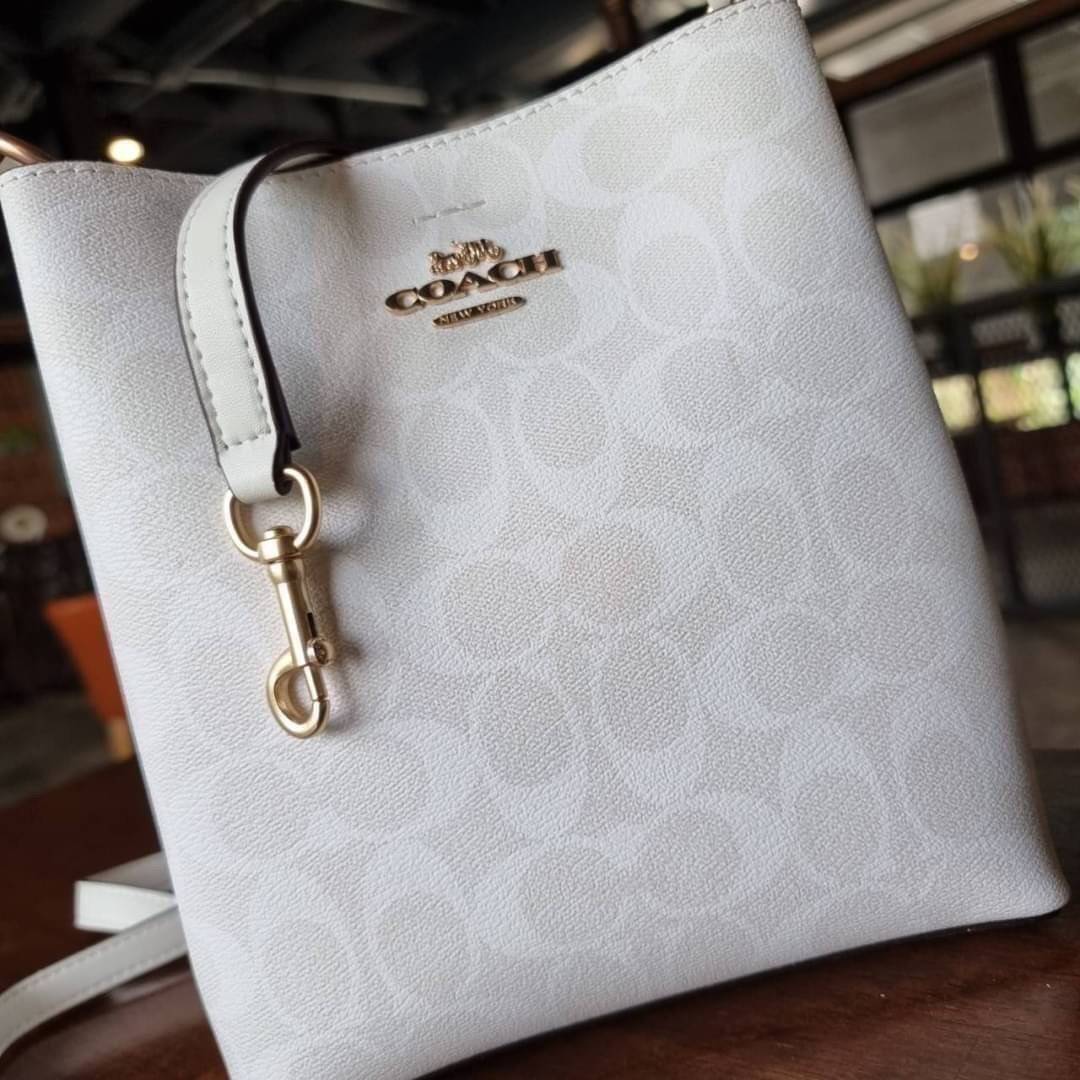 COACH 2312 SMALL TOWN BUCKET BAG IN SIGNATURE CANVAS รุ่นยอดนิยมใบเล็กมาครบสีแล้วจ้า กระเป๋าทรงบัคเก็ต สีผู้ดี๊ผู้ดี ตัวกระเป๋าดีไซน์คลาสสิคลายซี ดูโดดเด่น วัสดุหนังแคนวาสเคลือบลาย สวยคมทุกมุมจริงๆ!! เปิด-ปิดด้วยกระดุมแม่เหล็กทั้ง 2 ฝั่ง ภายในเป็นช่องโล่ง