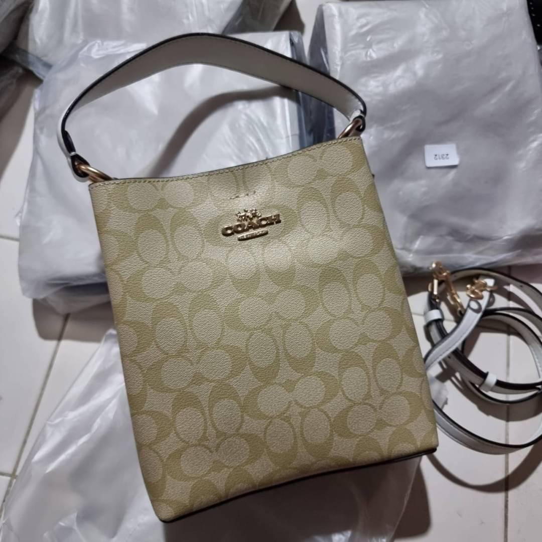 COACH 2312 SMALL TOWN BUCKET BAG IN SIGNATURE CANVAS รุ่นยอดนิยมใบเล็กมาครบสีแล้วจ้า กระเป๋าทรงบัคเก็ต สีผู้ดี๊ผู้ดี ตัวกระเป๋าดีไซน์คลาสสิคลายซี ดูโดดเด่น วัสดุหนังแคนวาสเคลือบลาย สวยคมทุกมุมจริงๆ!! เปิด-ปิดด้วยกระดุมแม่เหล็กทั้ง 2 ฝั่ง ภายในเป็นช่องโล่ง