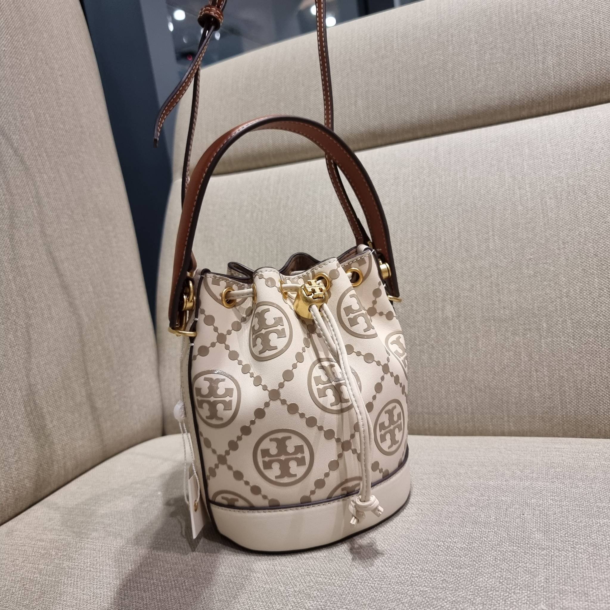 TORY BURCH T MONOGRAM EMBOSSED MINI BUCKET BAG คอลเลคชั่นใหม่ กับกระเป๋าบัคเก็ตทรงยอดนิยม ในไซส์มินิ ดีไซน์ใหม่ล่าสุด สวยลูกคุณหนู หรูหรา!! ด้วยดีเทลผิวลายนูนลวดลายเอกลักษณ์ วัสดุหนังแท้ ปากกระเป๋ารูดเปิด-ปิดได้ มีหูจับในตัว สะดวกใช้ไปอีก และมีสายสะพายข้า