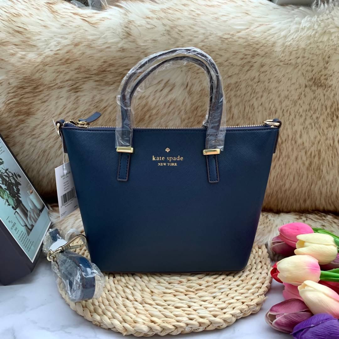 ของแท้ 💯% Kate Spade New York Cross Body Bag กระเป๋าถือหรือสะพาย หนัง Saffiano ภายในมีช่องซิปและช่องเล็ก มีหมุดรองฐานกันรอย 4 มุม อะไหล่ทองทั้งใบ ขนาดกำลังดี ใส่กระเป๋าสตางค์ยาวได้ค่ะ