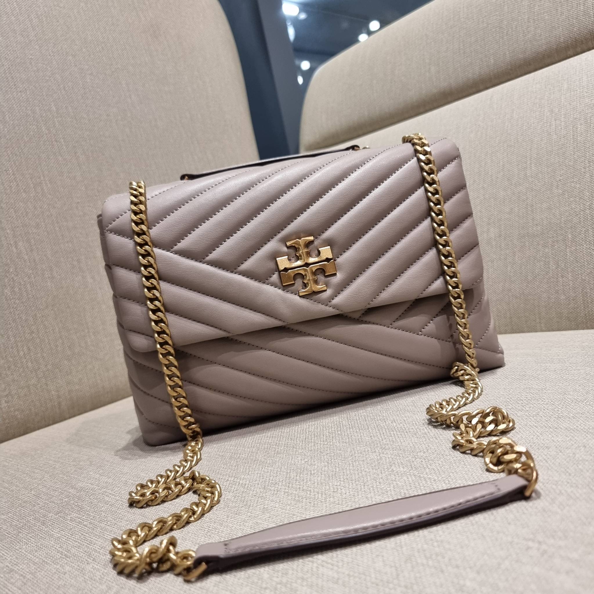 TORY BURCH KIRA CHEVRON CONVERTIBLE SHOULDER BAG กระเป๋าสะพายรุ่นยอดฮิต ไซส์ใหญ่จัดเต็มให้เน้นๆ ใช้ยังไงก็ดูหรู ดีไซน์เฉพาะตัว วัสดุหนังแกะ สัมผัสนิ่ม เปิด-ปิดด้วยกระดุมแม่เหล็ก ภายในเป็นช่องโล่ง แบ่งสัดส่วนไว้ดีมากๆ ใส่กระเป๋าสตางค์ มือถือ เครื่องสำอางค์