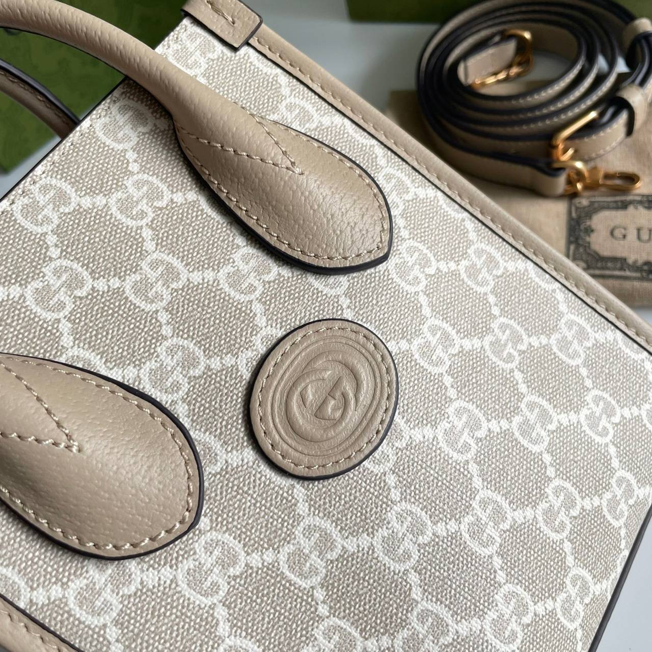 หนังแท้ GUCCI Mini tote bag with Interlocking G พร้อมส่งที่ไทย Beige and white GG Supreme canvas เกรดออริจินอล ภาพสินค้าถ่ายจากงานขายจริง ใช้งานต่างประเทศได้ The mini tote bag is complete with an oatmeal leather trim and an Interlocking G tag.