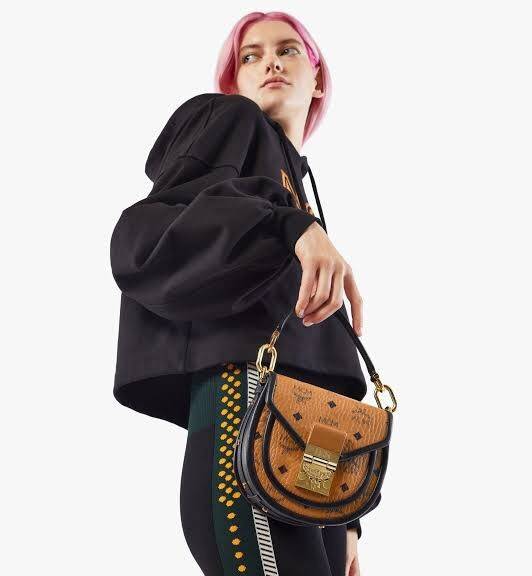 M.C.M MINI PATRICIA SHOULDER BAG IN VISETOS LEATHER BLOCK อัพเลเวลกระเป๋าของคุณด้วยไอเท็มนี้ไปเลยจ้า กระเป๋าสะพายทรง saddle ที่เก๋ไม่ซ้ำใคร ดีไซน์ขอบสีดำเพิ่มความยูนิค สวยสะดุดตา วัสดุหนังแคนวาสคุณภาพดี มาพร้อมสายสะพายหนังสีดำเรียบ และหูจับในตัว ทำให้ใช้ง