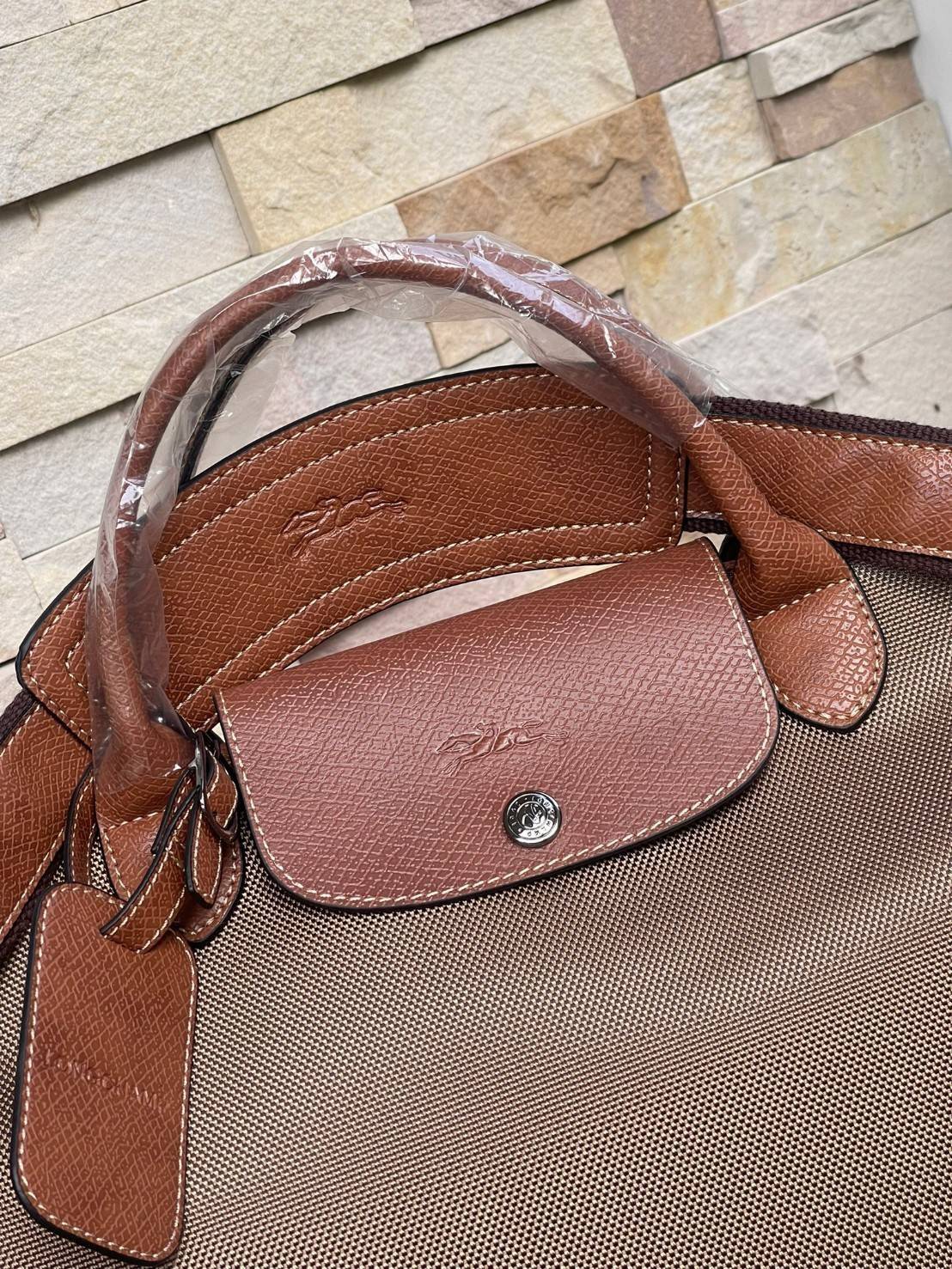 LONGCHAMP BOXFORD TRAVEL BAG L กระเป๋าเดินทางขนาดใหญ่ มาพร้อมสายสะพายที่สามารถถอดได้ ให้คุณเลือกสะพายไหล่หรือถือได้ มีซิปรูดเปิดปิดกระเป๋าที่ให้คุณมั่นใจได้ว่าคุณจัดเก็บไอเท็มของคุณได้อย่างมิดชิด บ็อคฟอร์ด (BOXFORD) สะท้อนความเป็นเอกลักษณ์ของแบรนด์ที่เปี่