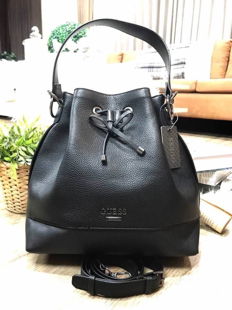 GUESS. DRAWSTRING BUCKET BAG WITH STRAP กระเป๋าถือหรือสะพายแบรนด์ดังรุ่นยอดนิยม วัสดุหนังแกะสังเคราะห์แบบนิ่มสวยอยู่ทรง ด้านหน้าประดับโลโก้ เปิดปิดแบบ Drawstring มาพร้อมสายสะพาย 2แบบ ทั้งสายสั้นสะพายไหล่และสายยาว crossbody ปรับระดับได้ ภายในกว้างมีช่องซิป