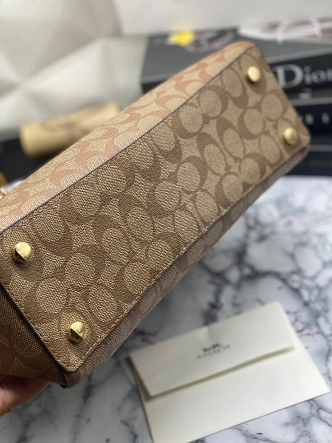 COACH Tote in Signature Canvas Bag กระเป๋าสะพายทรงช้อปปิ้ง สายกระเป๋าเป็นหนังสลับโซ่ทองสวยงาม เพิ่มความหรูหรา ภายในโล่งกว้างใส่ของได้เยอะมาก วัสดุ Canvas เคลือบลายซิกเนเจอร์และหนัง พร้อมซิปกลางเก็บของได้มิดชิดเลยค่ะ มี 3 สี น้ำตาล ดำ ขาว