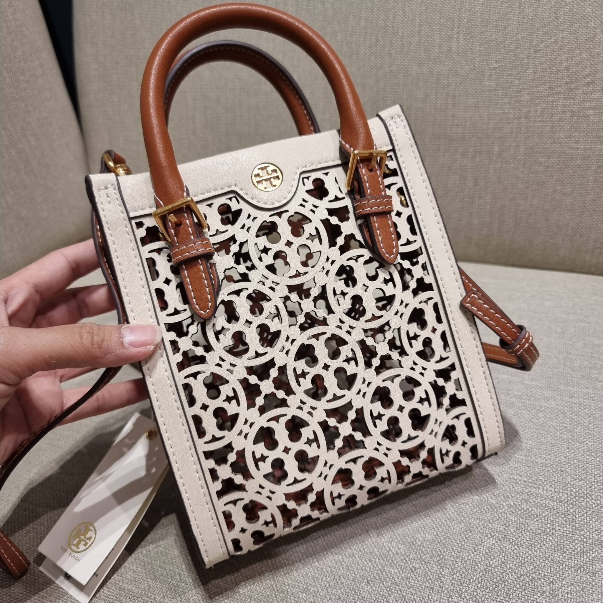TORY BURCH T MONOGRAM LASER-CUT MINI TOTE ใจบางที่สุดกับคอลเลคชั่นนี้ กับกระเป๋าสะพายทรงโท้ท ไซส์มินิ ที่เพิ่มดีเทลความแพงด้วยการฉลุลวดลายโมโนแกรมรอบใบ ถักทอเป็นเส้นลายสานที่สวยงามมาก งานฝีมือจริงๆ วัสดุหนัง cowhide ปากกระเป๋ามีแถบแม่เหล็กกันหล่น และมีหูจ