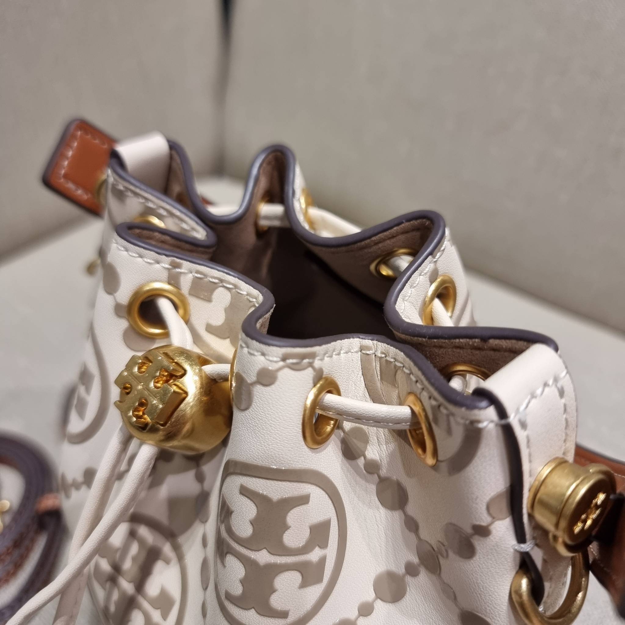 TORY BURCH T MONOGRAM EMBOSSED MINI BUCKET BAG คอลเลคชั่นใหม่ กับกระเป๋าบัคเก็ตทรงยอดนิยม ในไซส์มินิ ดีไซน์ใหม่ล่าสุด สวยลูกคุณหนู หรูหรา!! ด้วยดีเทลผิวลายนูนลวดลายเอกลักษณ์ วัสดุหนังแท้ ปากกระเป๋ารูดเปิด-ปิดได้ มีหูจับในตัว สะดวกใช้ไปอีก และมีสายสะพายข้า