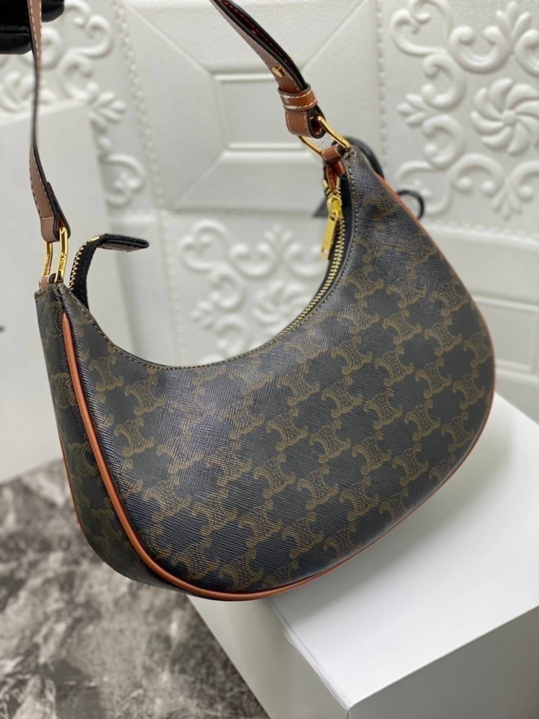 หนังแท้ CELINE AVA / CELINE Vintage Classic Ava bag 1 ใน คอลเลคชั่น “Triomphe Canvas” มาพร้อมสายสะพายไหล่ที่ปรับความยาวได้ และเนื่องจากช่วงล่างของกระเป๋ามีขนาดใหญ่กว่าช่วงบน จึงทำให้ไม่เสียทรงเมื่อเราใส่สิ่งของอย่างกระเป๋าสตางค์หรือโทรศัพท์มือถือ หากดูภาพ