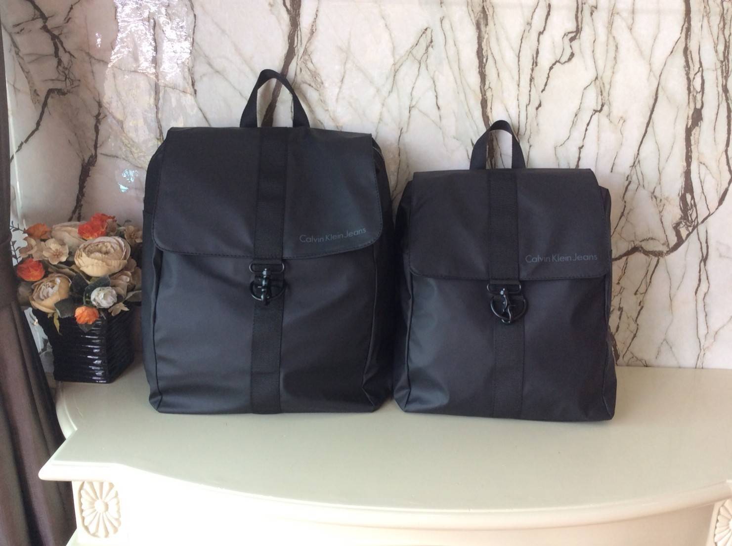 CALVIN KLEIN JEANS NYLON BACKPACK กระเป๋าสะพายเป้มี 2 size ให้เลือกตามการใช้งาน วัสดุ Nylon + Polyester 100% น้ำหนักเบา กันน้ำปานกลาง ด้านหน้าสกรีนโลโก้ Calvin Klein Jeans เปิดปิด 2 ชั้น ด้วยตัวล็อค เเละซิปเดียวด้าน ภายในกว้าง ใส่ A4, iPad หรือเสื้อผ้าได้