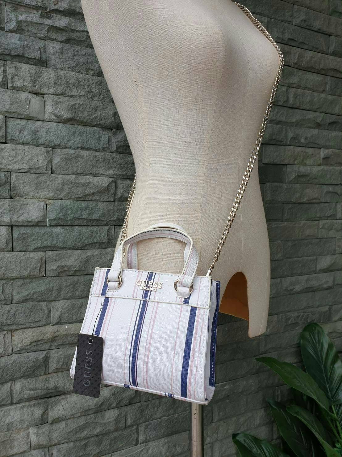 GUESS TAYLOR MINI SATCHEL CROSSBODY BAG กระเป๋าสะพายใบเล็ก สไตล์ สวยหรู คุณหนู ไฮโซ น่ารักมากๆ วัสดุหนังpu เย็บลายตาราง หนังนิ่ม จับนุ่มมือ และ ลายทาง หนัง saffiano ตั้งอยู่ทรง แบบน่ารักไม่ซ้ำใคร ด้านหน้าประดับโลโก้แบรนด์ อะไหล่ทอง มาพร้อมสายโซ่ ถอดออกได้