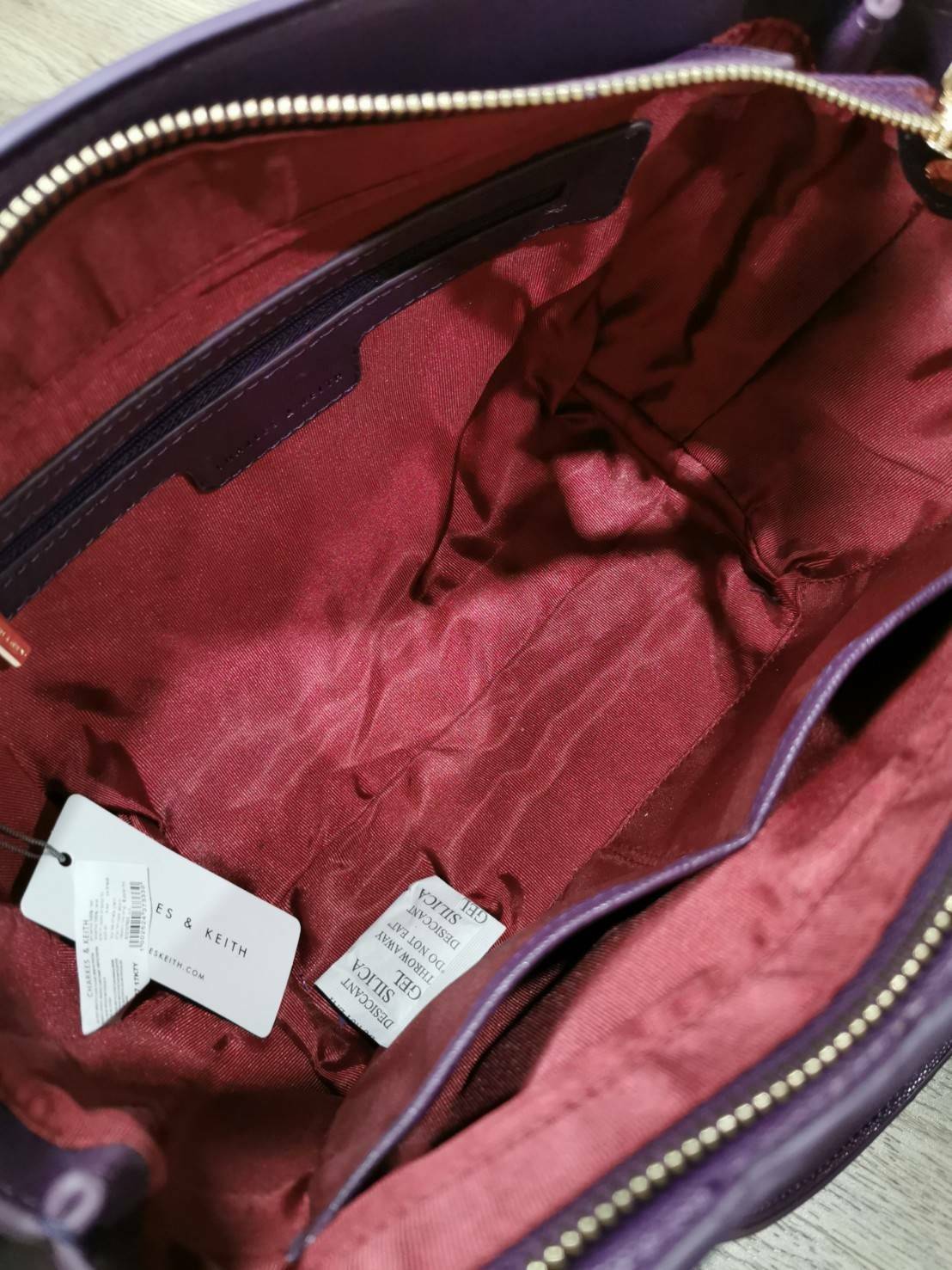 CHARLES & KEITH SAFFIANO TRAPEZE BAG กระเป๋าถือหรือสะพายรุ่นยอดนิยมดีไซน์สวยหรูวัสดุหนังคาเวียร์อยู่ทรง ด้านข้างเเต่งหนังช่องตัดดูมีดีเทล ด้านหน้ามีโลโก้ ด้านหลังมีช่องซิป เปิดปิดด้วยซิปหัวซิปแบรนด์ หูจับเเข็งแรง พับลงได้ พร้อมสายสะพายหนังปรับระดับได้ถอดไ