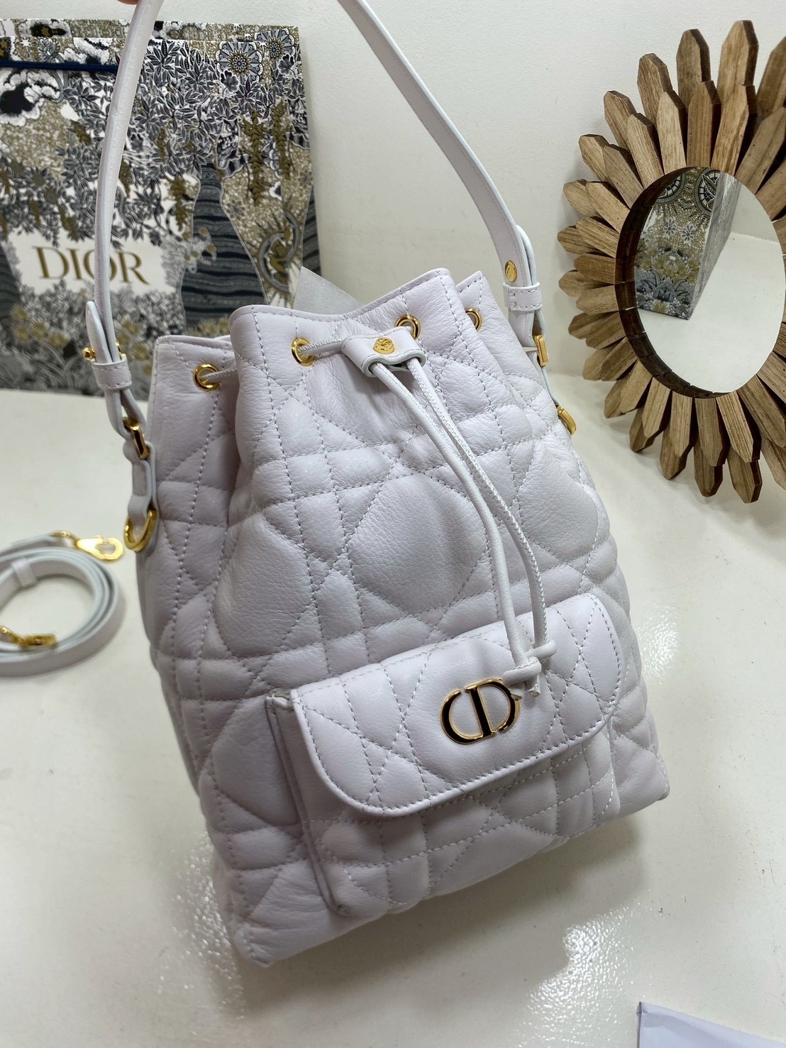 ORI หนังแท้ | Small Dior Caro bucket bag กระเป๋าทรงบักเก็ต รุ่นใหม่ประจำ Fall 2025 โดดเด่นด้วยดีไซน์ที่ทันสมัยและสง่างาม ได้รับการรังสรรค์ขึ้นจากหนังแกะสีดำเดินด้ายลาย Macrocannage พร้อมกับช่องเก็บของขนาดใหญ่แบบเชือกรูดปิด
