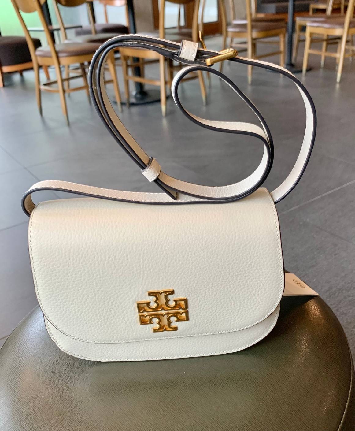 TORY BURCH BRLTTEN SMALL SADDLE BAG / Tory Burch Britten Flap Shoulder Bag กระเป๋าสะพายข้าง วัสดุหนังแกะแท้ ด้านหน้าประดับโลโก้แบรนด์ เปิด-ปิดกระเป๋าแบบกระดุมแป็กแม่เหล็กแน่นหนา ภายในมีช่องหลัก ใส่กระเป๋าเงินใบกลาง มือถือได้ทุกรุ่น มีช่องแยกใส่ของจุกจิกอี