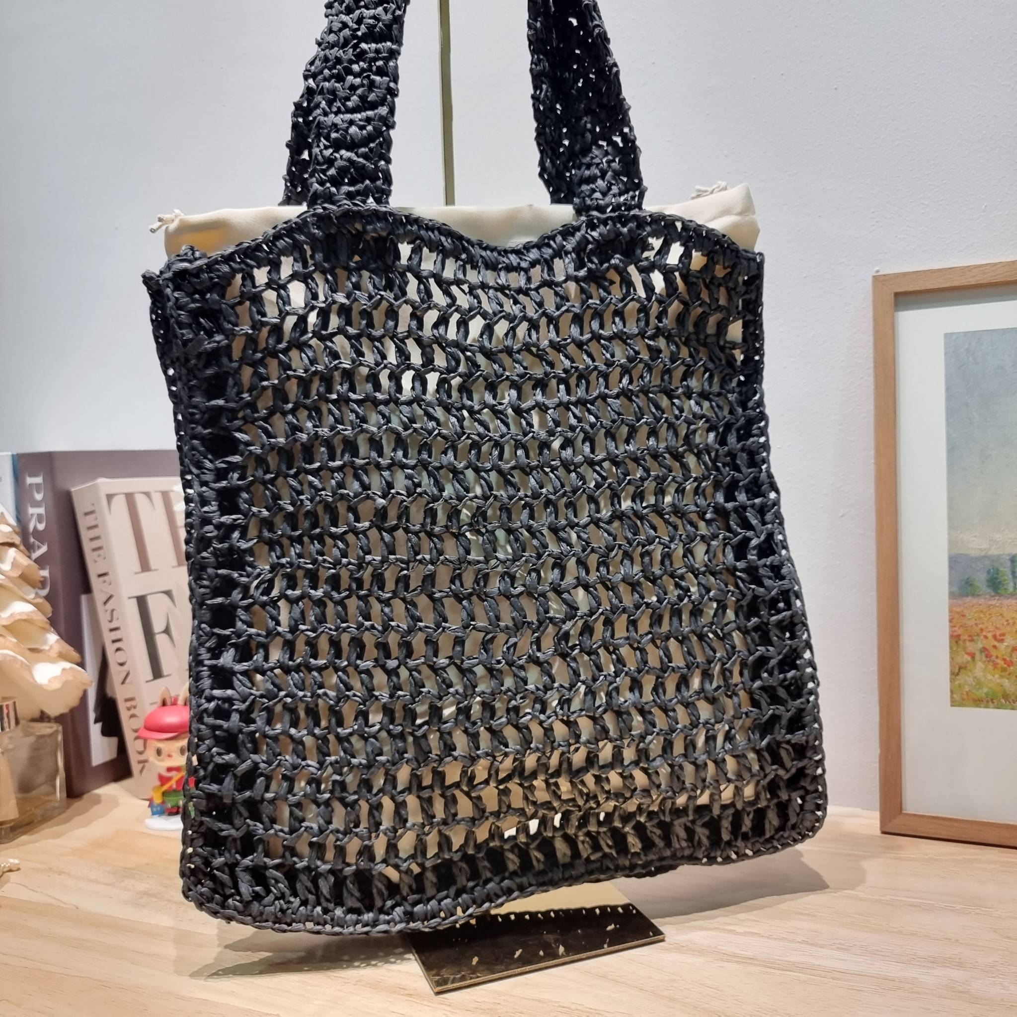 PRADA RAFFIA TOTE BAG สวยไม่ซ้ำใคร สไตล์บีช เหมาะมากกับการสะพายไปเที่ยวทะเล หรือจะใช้ในวันสบายๆก็ตอบโจทย์ กับกระเป๋าสะพายสานใบใหญ่ ตัวกระเป๋าเป็นวัสดุสังเคราห์จากธรรมชาติ