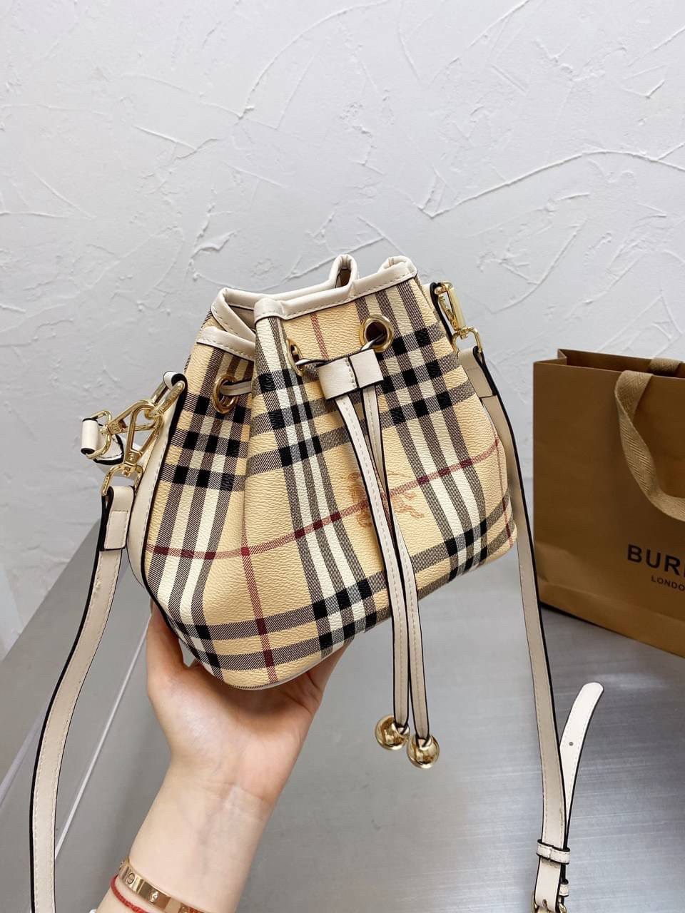 BURBERRY MINI BUCKET VINTAGE LEATHER BAG งานพรีเมียมกิ้ฟท์เคาเตอร์ น้ำหอมจากแบรนด์ วัสดุหนัง PVC ทรงขนมจีบสุดคิ้วท์ เนื้อหนาซับในอย่างดี กระเป๋าสามารถ จุของได้เยอะมาก ด้านในมีช่องซิปพร้อมช่องใส่ของอีกหนึ่งช่อง ถือแล้วสวยมากๆ จุของได้กำลังดี ทรงนี้ต้องมีติ