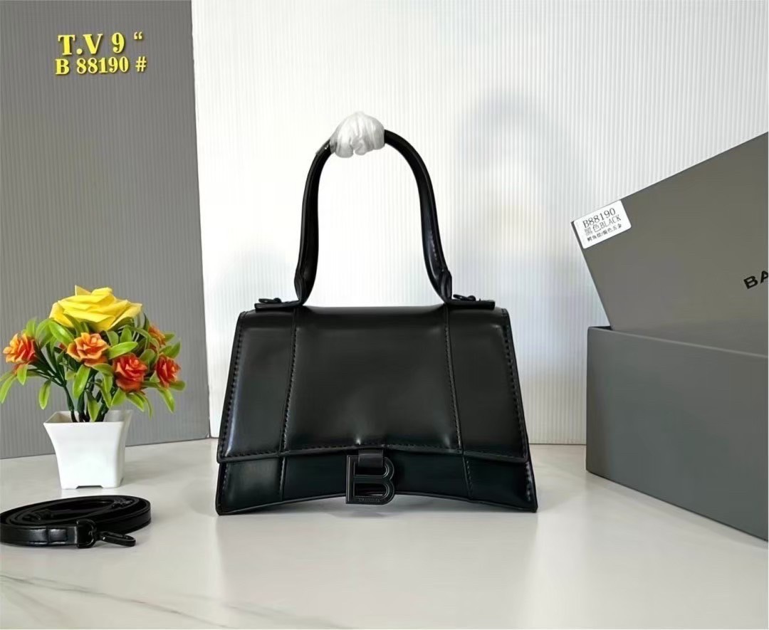 BALENCIAGA Hourglass top-handle tote bag กระเป๋าสะพายแบรนด์หรูซิกเนเจอร์ ที่มาพร้อมดีไซน์โดดเด่น มีความโฉบเฉี่ยว โค้งมนเหมือนพระจันทร์เสี้ยว เพิ่มความสวยสะดุดตาด้วยการตกแต่งอักษร B เมทัลลิก