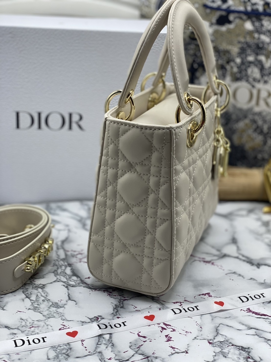 หนังแท้ DIOR LADY BAG 20cm ความสง่างามอีกหนึ่งรุ่นของ Dior รูปทรงสีเหลียม ขนาดกระทัดรัด ตั้งอยู่ทรง ฐานกระเป๋าแข็งแรง มีหมุดรองฐาน ดีไซน์ที่มีเอกลักษณ์เฉพาะตัว ด้านหน้าตกแต่งด้วยตัวอักษร D.I.R ห้อยเป็นพวงกุญแจ จะถือด้วยมือหรือสะพายไหล่ก็ดูดีมากๆ ค่ะ