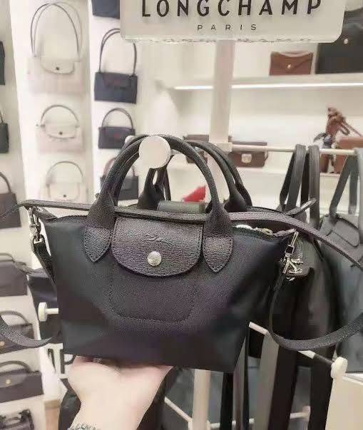 LONGCHAMP LE PLIAGE NÉO TOP HANDLE BAG XS คอลเลคชั่นสุดพิเศษจากลองฌอมป์ มีดีไซน์ที่เรียบหรูและคลาสสิก แฝงด้วยลูกเล่นแบบเฟมินีน แถมยังมีน้ำหนักเบาอย่างไม่น่าเชื่อ มาพร้อมกับหูจับกระเป๋าคู่และฝาปิดแบบกระดุม กระเป๋าถือใบนี้สามารถใช้ถือแบบทั่วไป มีสายสะพายถอด
