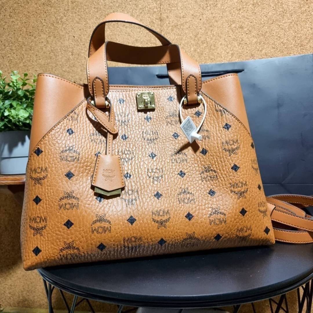 M.C.M ESSENTIAL TOTE IN VISETOS ความจุใจมาพร้อมเสิร์ฟแล้วจ้า ใครที่มองหากระเป๋าทรงโท้ทจุๆ ต้องใบนี้เลย!! กระเป๋าสะพายไหล่/ข้าง ดีไซน์ทรงสวยน่าใช้ วัสดุหนังแคนวาสสลับหนังแท้ ปากกระเป๋ามีตัวบิดล็อคแน่นหนากันของหล่นออกจากกระเป๋า ภายในโล่งกว้าง แบ่งสัดส่วนอย่