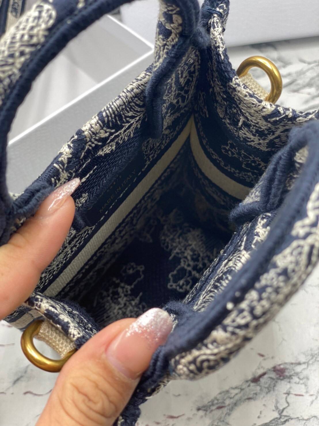 ORI 】Mini Dior Book Tote Phone Bag พร้อมส่งที่ไทย ภาพสินค้าถ่ายจากงานขายจริง ใช้งานต่างประเทศได้ กระเป๋าใบมินิจะใส่โทรศัพท์ได้เช่นเดียวกับของใช้จำเป็นเล็กๆ น้อยๆ ในแต่ละวัน มาพร้อมสายสะพายไหล่แบบปักที่ปรับได้และถอดออกได้ อุปกรณ์เสริมอันทันสมัยนี้สามารถสวม