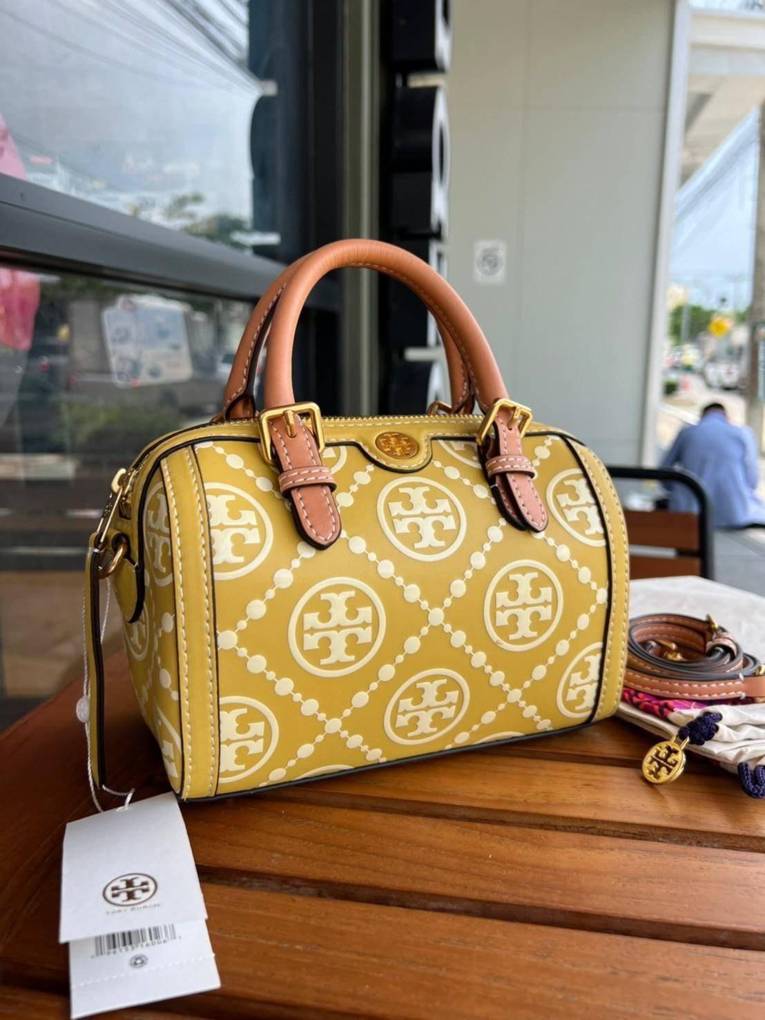Tory Burch T-Monogram Mini Embossed Wine Bucket Bag / Tory Burch Mini Bucket กระเป๋าถือหรือสะพายไหล่ ทรงหมอนขนาดเล็ก ประดับด้วยลวดลายอันเป็นสัญลักษณ์ของแบรนด์ ถูกประดิษขึ้นด้วยความพิถีพิถันวัสดุหนังอย่างดี ด้านในบุด้วยหนังไมโครซูแอคเนื้อนุ่มทำความสะอาดง่า