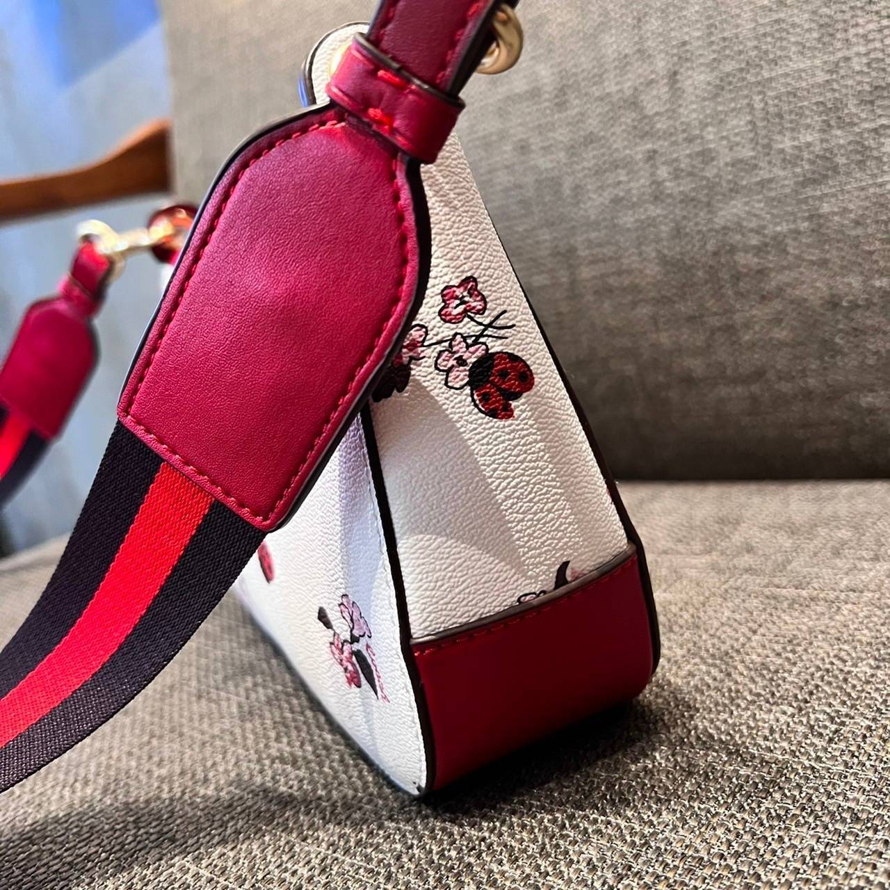 COACH C7973 JES BAGUETTE WITH LADYBUG FLORAL PRINT คอลเลคชั่นใหม่ล่าสุด พร้อมเสิร์ฟความสวยถึงบ้านเช่นเคย!! กระเป๋าสะพายทรงบาแกตต์ ดีไซน์ย้อนยุค ที่แอบแฝงความเรียบหรูดูแพงอยู่ในตัว โดดเด่นด้วยสายสะพายเส้นใหญ่ โทนสีคอนทราส ทำให้ไอเท็มนี้ดูมีลูกเล่นมากขึ้น ว