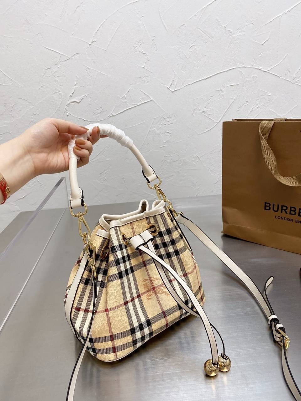 BURBERRY MINI BUCKET VINTAGE LEATHER BAG งานพรีเมียมกิ้ฟท์เคาเตอร์ น้ำหอมจากแบรนด์ วัสดุหนัง PVC ทรงขนมจีบสุดคิ้วท์ เนื้อหนาซับในอย่างดี กระเป๋าสามารถ จุของได้เยอะมาก ด้านในมีช่องซิปพร้อมช่องใส่ของอีกหนึ่งช่อง ถือแล้วสวยมากๆ จุของได้กำลังดี ทรงนี้ต้องมีติ