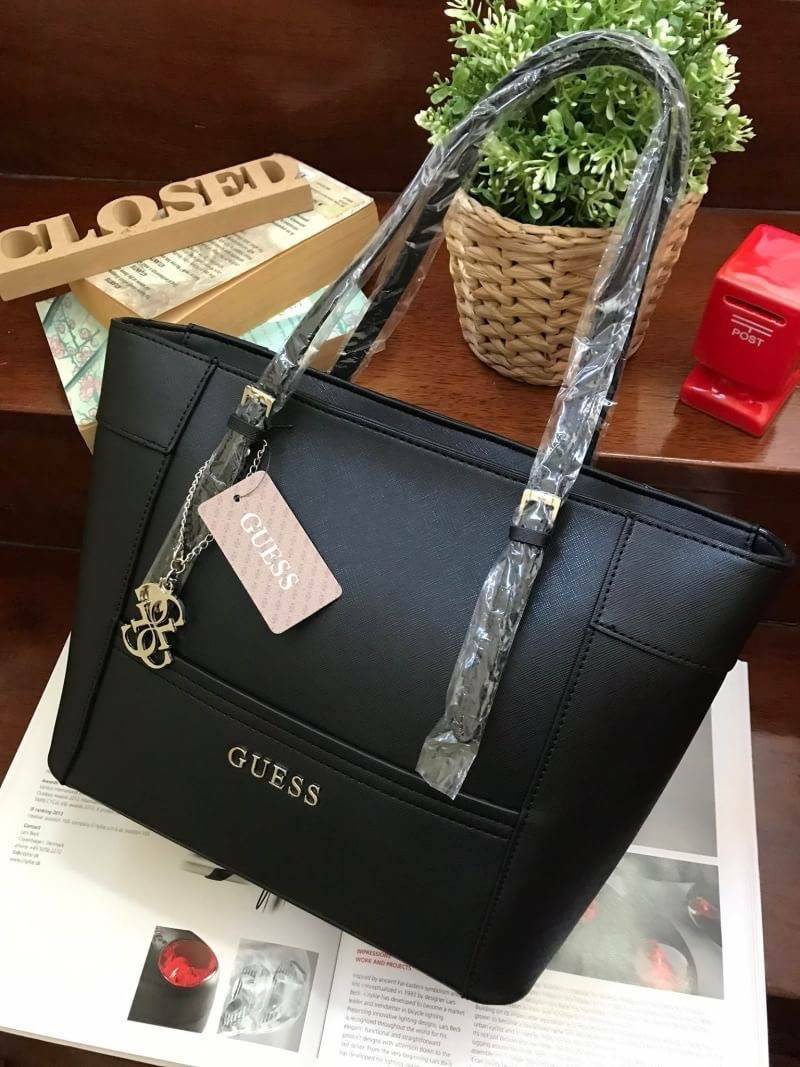 GUESS SHOPPER BAG กระเป๋าถือทรง Tote วัสดุหนังลาย Saffiano สวยอยู่ทรงสไตล์ PRADA ขนาดใหญ่ น้ำหนักเบา ด้านหน้าปั้มโลโก้แบรนด์ ประดับโลหะTAG โลโก้ตัว G อะไหล่เงินที่หูกระเป๋าถอดเเยกใช้ได้ เปิดปิดด้วยซิปเดียวใช้งานง่ายภายในมีsignature ยังมีช่องซิปและช่องเล็ก