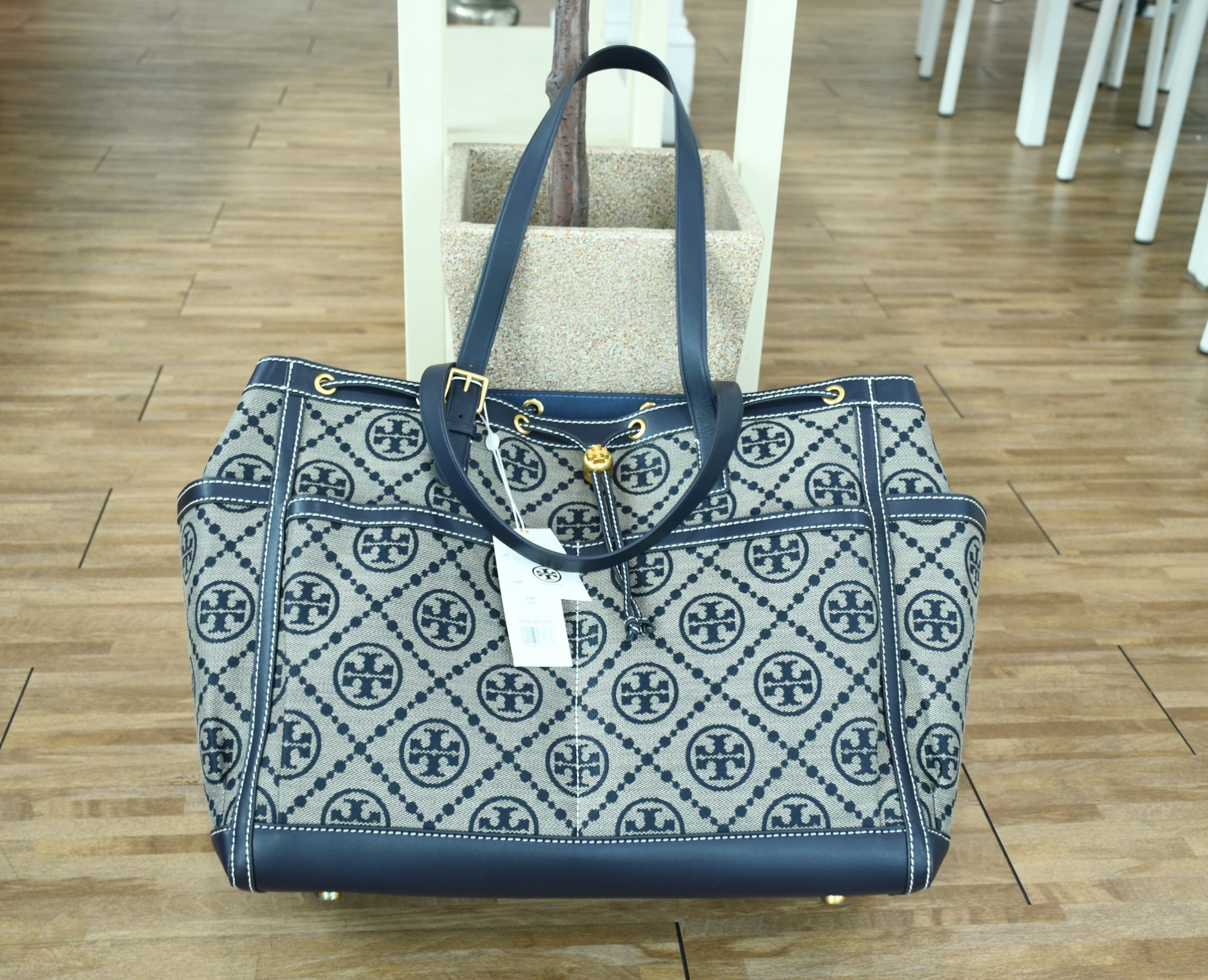OUTLET 】TORY T MONOGRAM JACQUARD WFH TOTE กระเป๋าถือหรือสะพายไหล่ วัสดุ Canvas ปักษ์ลายแบรนด์ อะไหล่ทองสวยหรู น้ำหนักเบา จุของได้เยอะ ด้านหน้ามีกระเป๋าเล็ก2ช่อง ด้านหลัง2ช่อง ด้านในโล่ง มีช่องใหญ่1ช่อง ช่องเล็ก1ช่อง และอีก1ช่องซิป ใบใหญ่ Size XL ใส่เสื้อผ