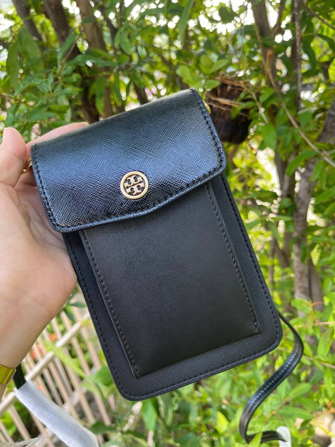OUTLET 】Tory burch robinson mixed materials phone crossbody ไอเท็มหรูจากแบรนด์ดังอย่างTory burch อีกแบรนด์สุดคลาสสิกที่มีทั้งความเท่และความเรียบหรูลงตัว กับรูปทรงแบบมินิมอลสีเหลี่ยมมุมโค้งเรียบ ๆ ดีไซน์ฝาพับปิดกระเป๋าได้มิดชิด ยังมีลักษณะที่แนบกับตัวผู้ใช