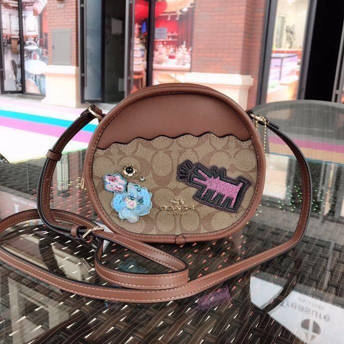 COACH KEITH HARING CANTEEN CROSSBODY IN SIGNATURE CANVAS WITH PATCHES F48730 กระเป๋าทรงกลมสุดเก๋ ไม่เหมือนใคร ตกแต่งลายให้มรความน่ารัก โดดเด่นขึ้นมา สะพายไปไหนก็สวยไม่เหมือนใคร ภายในกว้าง ใส่ของได้เยอะ กระเป๋าเปิดปิดด้วยซิป ใครย้งไม่มี รีบจับ รีบจองกันเลย