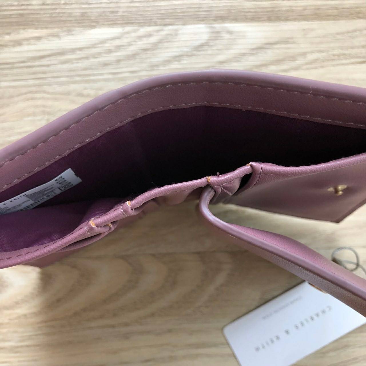 Charles & Keith Classic Snap-Button Wallet กระเป๋าสตางค์ใบสั้นพับ 2 ตอน ด้านหน้ามีโลโก้แบรนด์ เปิด - ปิดด้วยกระดุม ภายในมีช่องใส่ธนบัตร ช่องใส่บัตร และช่องซิปใส่เหรียญ