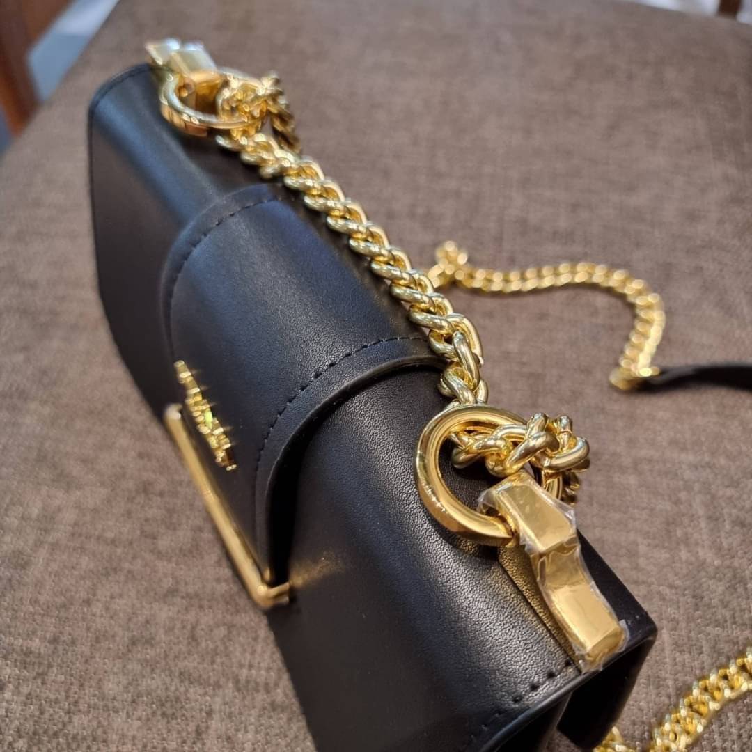 PRADA FRAGRANCE SHOULDER BAG WITH GWP ไอเท็มสุดโปรดที่ควรค่าแก่การครอบครองและเก็บสะสม กระเป๋าสะพายไหล่ สวยคม สีดำคลาสสิคตัดกับอะไหล่ทองเป็นอย่างดี วัสดุหนังแท้เต็มใบ เปิดปิดด้วยแถบหนังสอดในช่อง ใช้งานสะดวก พกพาง่าย ขนาดกำลังสวย สายสะพายในตัว สะพายได้หลากห