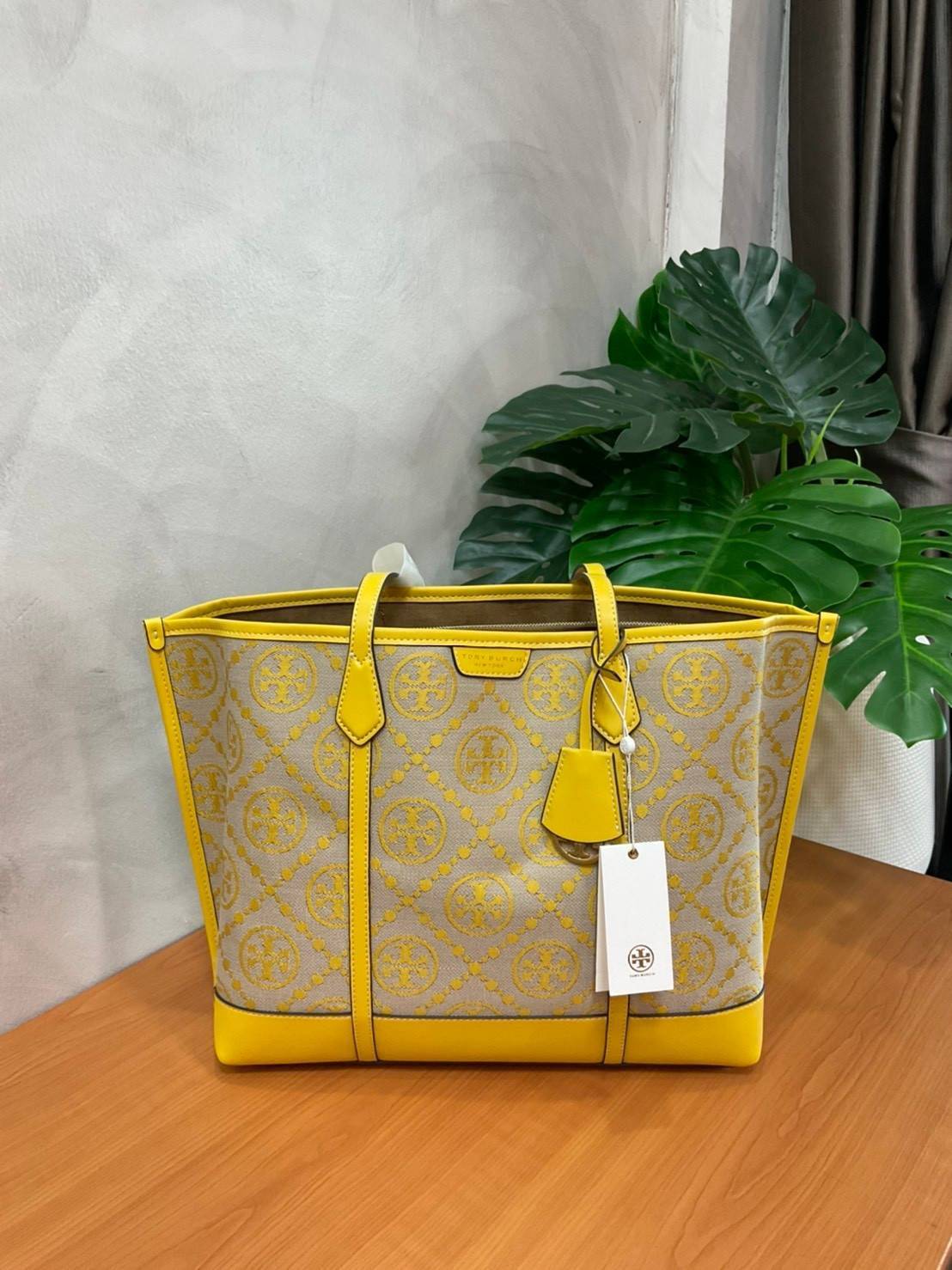 TORY BURCH T MONOGRAM TRIPLE - COMPARTMENT TOTE กระเป๋า/สะพายไหล่ทรง SHOPPING BAG วัสดุผ้าผ้าแคสวาสปักลายสัญลักษณ์แบรนด์ ตั้งอยู่ทรง สวยหรู ดูแพง จุของได้เยอะมาก ภายในแยกเป็น 2 ช่องหลัก 1 ช่องซิปตรงกลาง แบ่งเป็นสัดส่วนใช้งาน