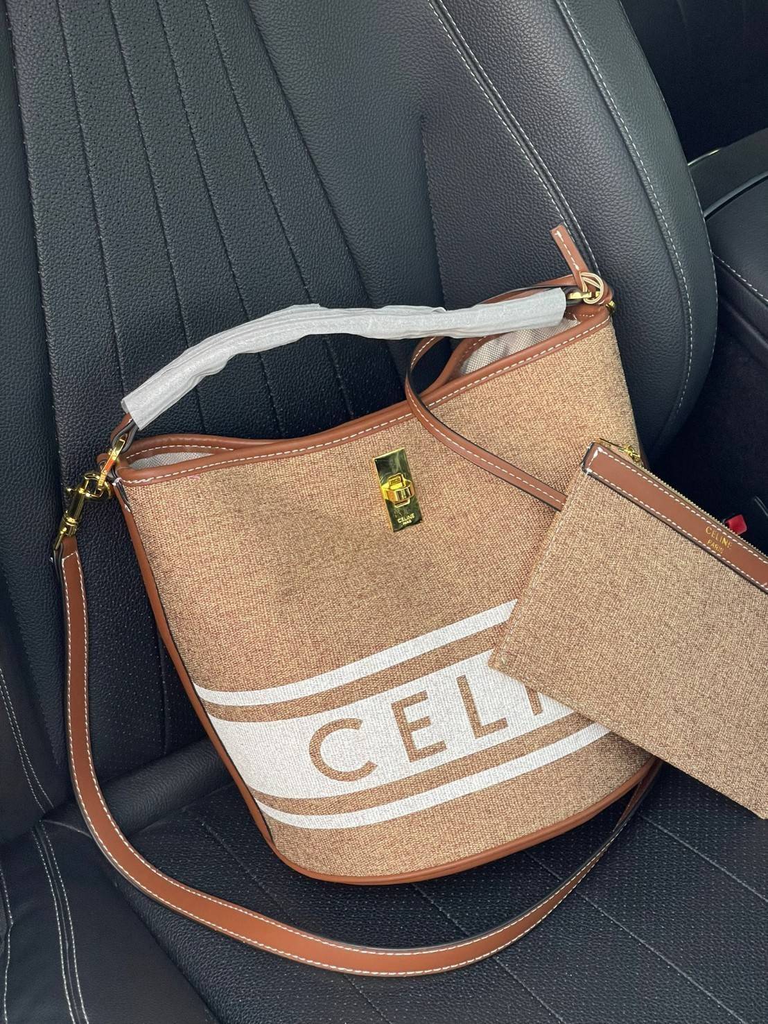 Celine Bucket Bag In Textile with Celine Logo สาว ๆ คนไหนกำลังมองหากระเป๋าสะพายที่สามารถจุของได้แบบกำลังพอดี เราขอแนะนำเป็นใบนี้เลยค่ะ เพราะมีขนาดที่ไม่เล็กและไม่ใหญ่จนเกินไป ให้ความคล่องตัวสูง มีฐานกว้างสามารถใช้สะพายไหล่เมื่อต้องการออกงานทางการหรือจะสะพ