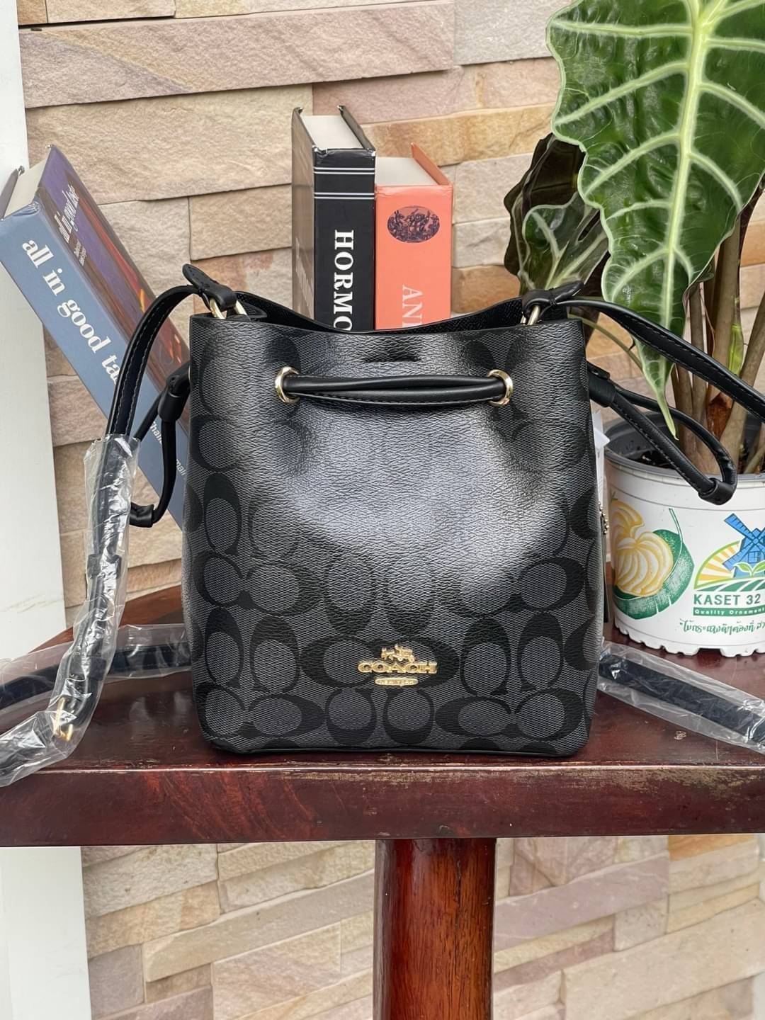 Coach Lena Crossbody Signature Bucket Bag กระเป๋าสะพายไหล่สุดคลาสสิกรุ่นนี้ เป็นรูปทรงถัง ที่สามารถจุของได้กำลังดี สำหรับสาวๆสายแฟชั่นที่ชอบรายละเอียดชิคๆ ดีไซน์เก๋ ด้วยรูปทรงของกระเป๋าที่ออกแบบมาให้ฐานเป็นรูปสี่เหลี่ยมทำให้กระเป๋ายังคงรูปทรงได้ง่าย มีสาย