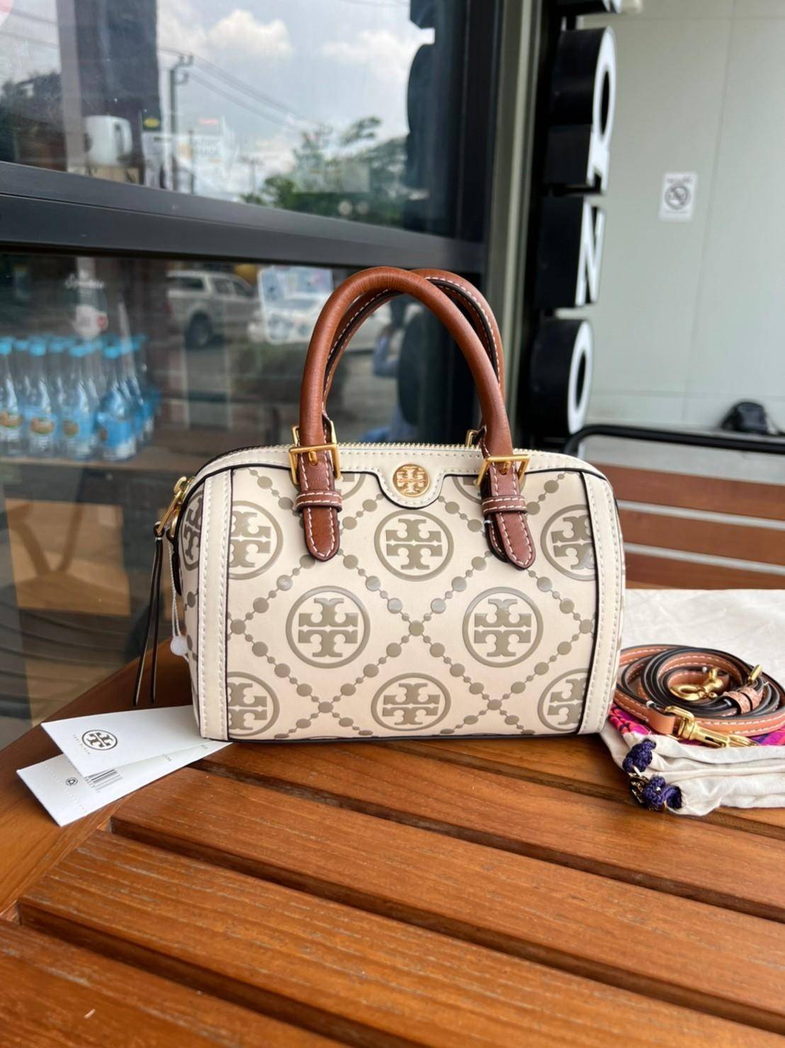 Tory Burch T-Monogram Mini Embossed Wine Bucket Bag / Tory Burch Mini Bucket กระเป๋าถือหรือสะพายไหล่ ทรงหมอนขนาดเล็ก ประดับด้วยลวดลายอันเป็นสัญลักษณ์ของแบรนด์ ถูกประดิษขึ้นด้วยความพิถีพิถันวัสดุหนังอย่างดี ด้านในบุด้วยหนังไมโครซูแอคเนื้อนุ่มทำความสะอาดง่า