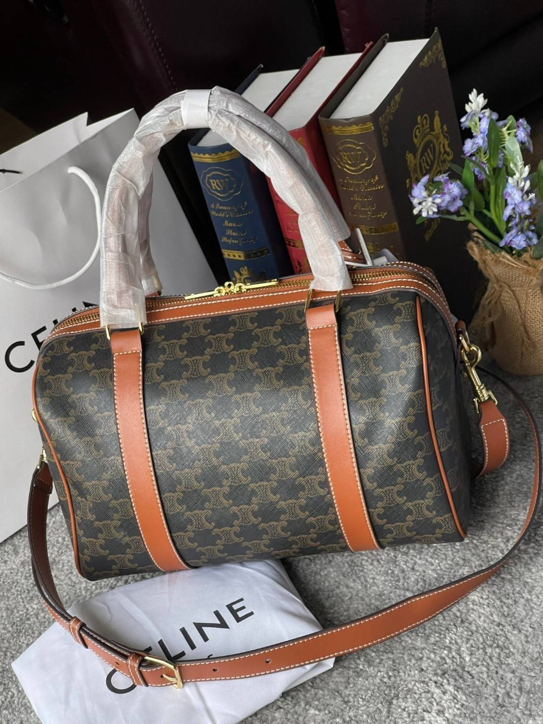 VIP 】CELINE BOSTON BAG IN TRIOMPHE CANVAS AND TAN ลวดลาย Triomphe Canvas Collection เป็นที่นิยมตลอดกาล มาในรูปแบบกระเป๋าทรงหมอนที่ได้รับความนิยมแบบทุกยุคทุกสมัย ซึ่งเป็นรูปทรงที่มีความคลาสสิก ดูดีแบบไม่มีตกยุค มาพร้อมขนาดที่ง่ายต่อการพกพา จัดเก็บหรือหยิบข