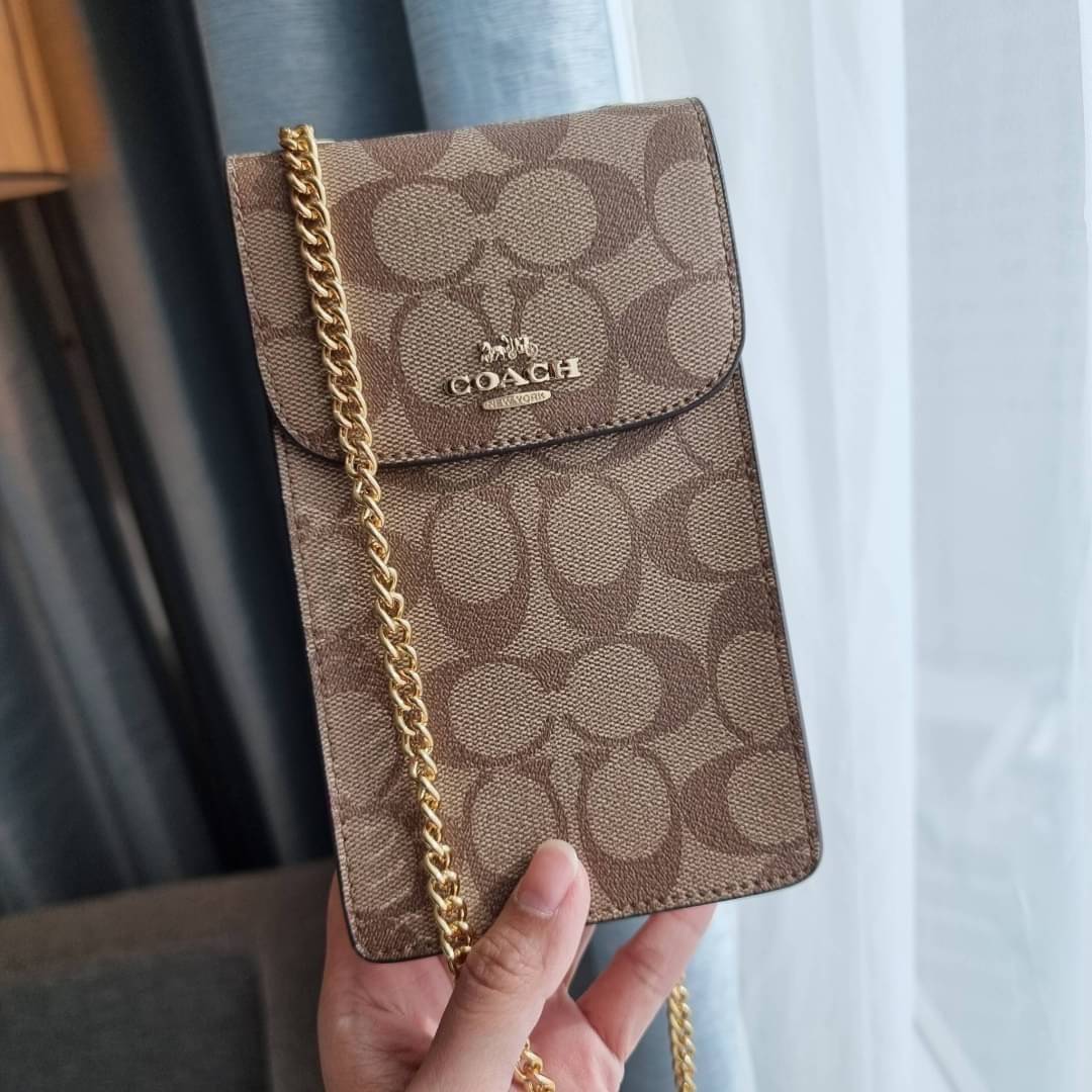 COACH NORTH/SOUTH PHONE CROSSBODY IN SIGNATURE CANVAS F55636 F39955 สุดคลาสสิคกับกระเป๋าสะพายเอนกประสงค์ Case phone ใส่โทรศัพท์มือถือได้ทุกรุ่น ดีไซน์ลายเอกลักษณ์ วัสดุหนังแคนวาสเคลือบลาย ฝาและภายในเป็นหนังสังเคราะห์เรียบ เปิด-ปิดด้วยกระดุม สายสะพายยาวประ